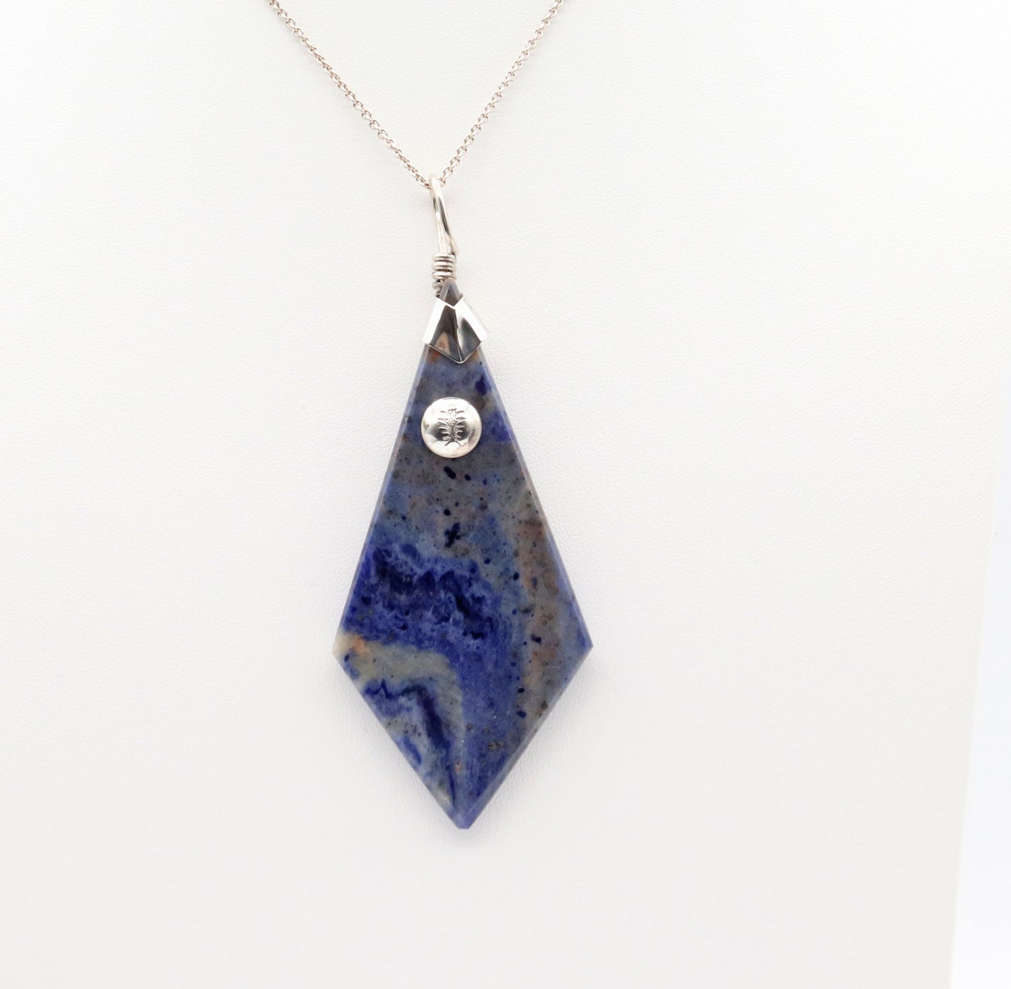 A 3.23 inch distinctive, rare and remarkable Foidolite igneous rock, expertly cut into a kite shape, polished, and elegantly presented with a custom crafted Argentium® Silver bail setting.