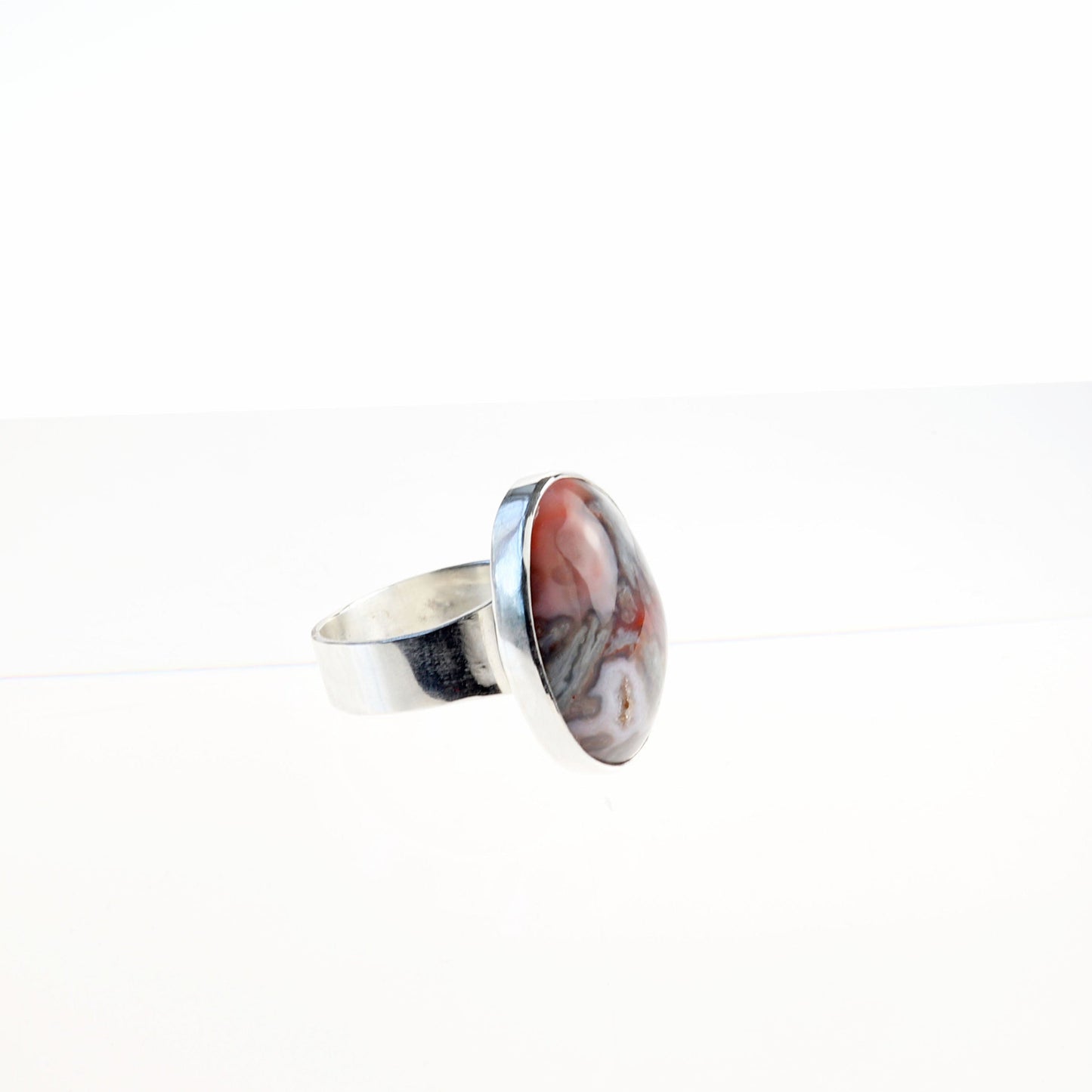 Alt size view of handmade Crazy Lace Agate Natural Cabochon Gemstone Ring. Featuring swirling patterns and vibrant hues of pink and gray and a unique Crystal feature within the stone. Encased in sterling 935 Argentium silver with a fine silver bezel.
