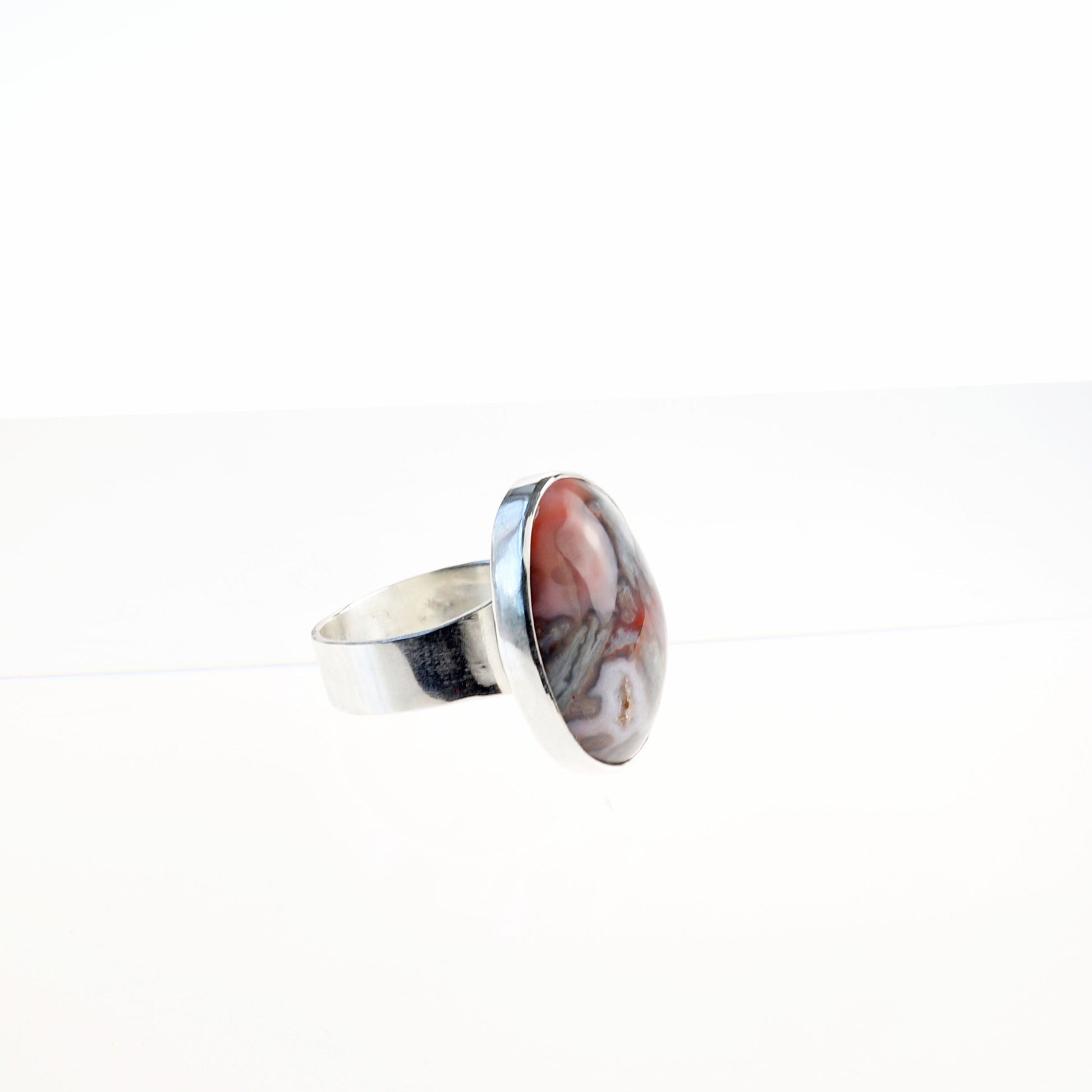 Alt size view of handmade Crazy Lace Agate Natural Cabochon Gemstone Ring.  Featuring swirling patterns and vibrant hues of pink and gray and a unique Crystal feature within the stone. Encased in sterling 935 Argentium silver with a fine silver bezel.