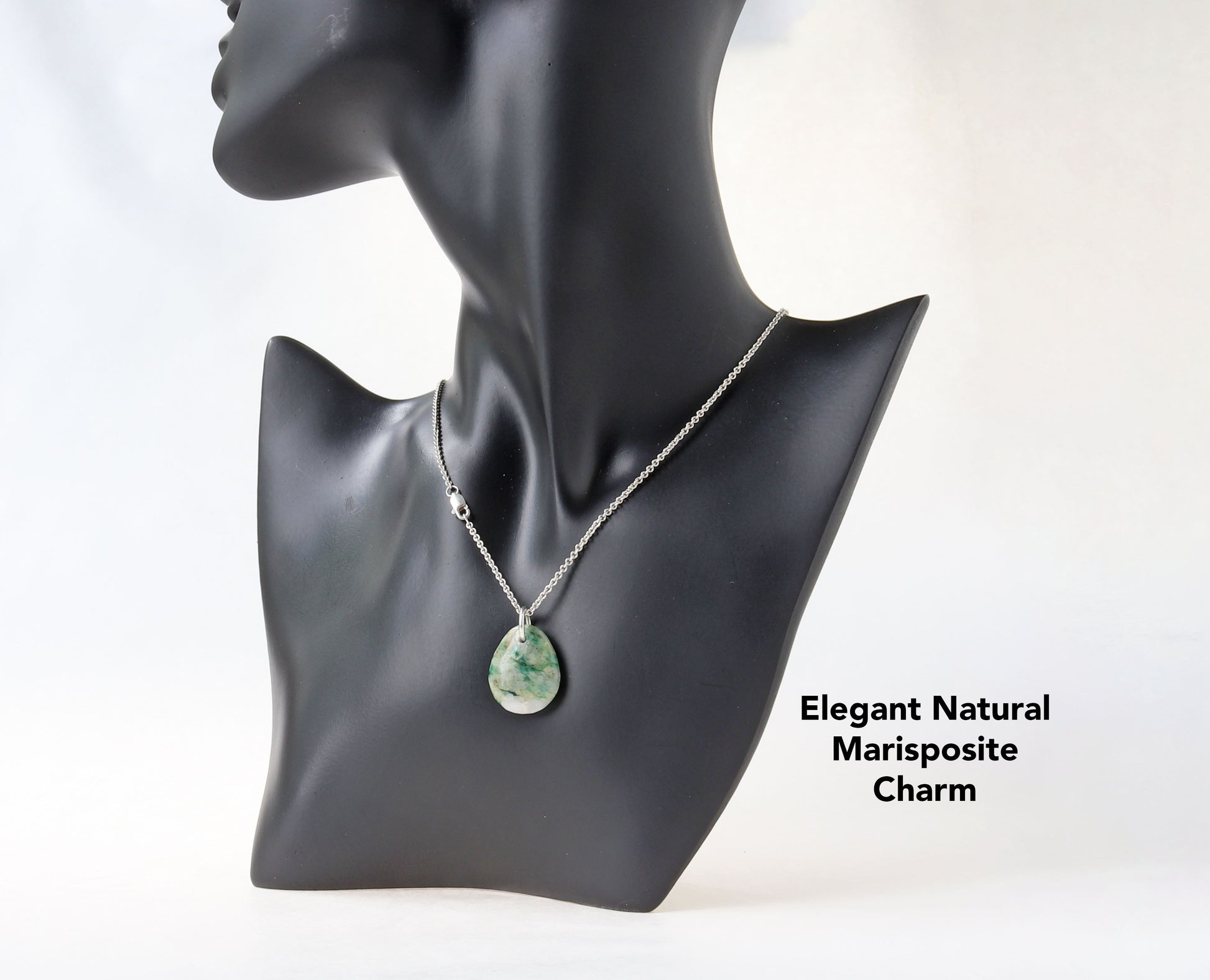 This teardrop-shaped Mariposite gemstone pendant charm showcases a vivid blend of green and white patterns, handcut and polished in our Missouri studio. shown attached to a silver chain on a black resin model.  To complete the look a Argentium silver chain is included.