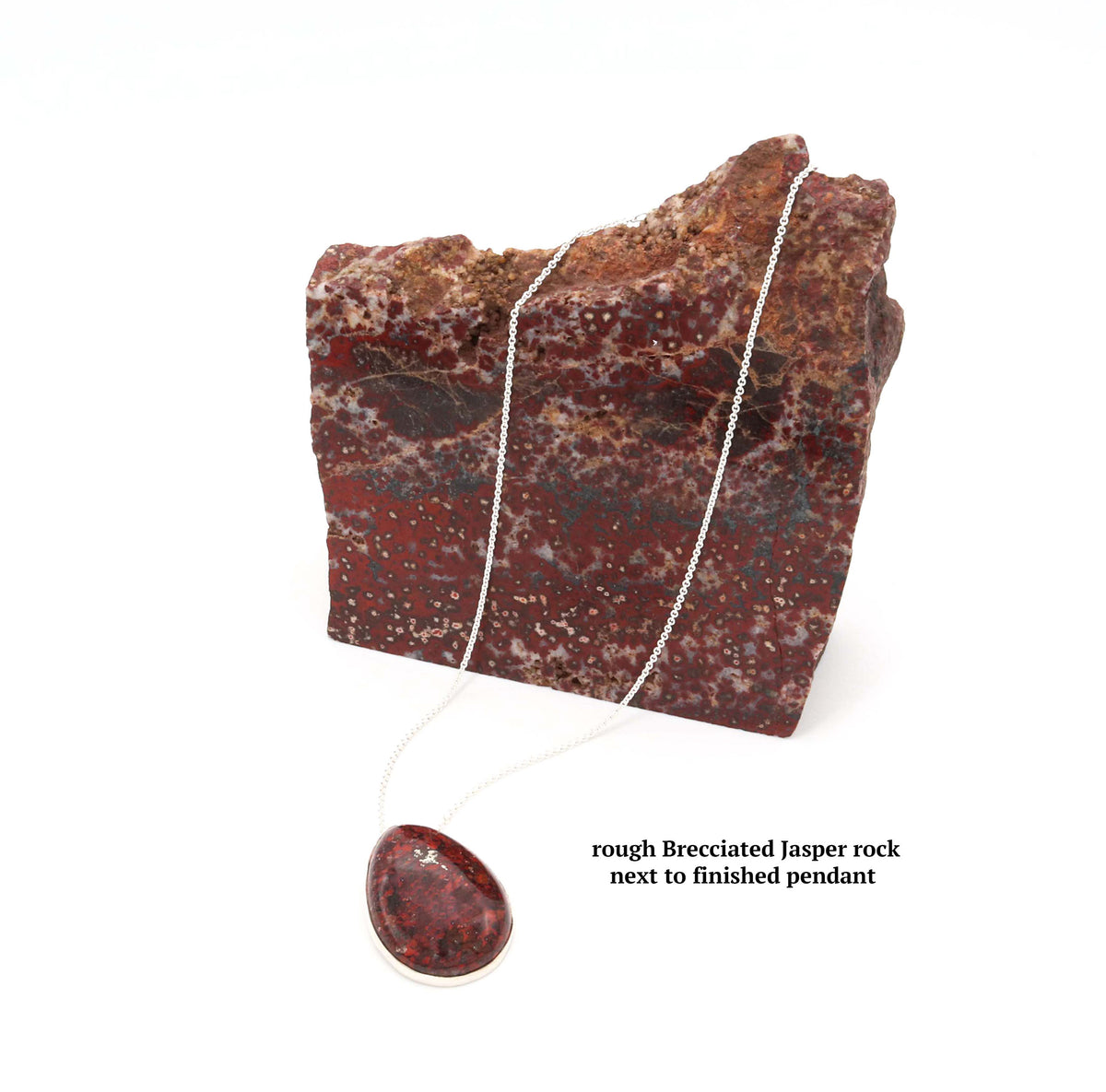 A rough natural Brecciated Jasper rock next to finished pendant with Argentium necklace chain. Text reads 'rough Brecciated Jasper rock next to finished pendant'