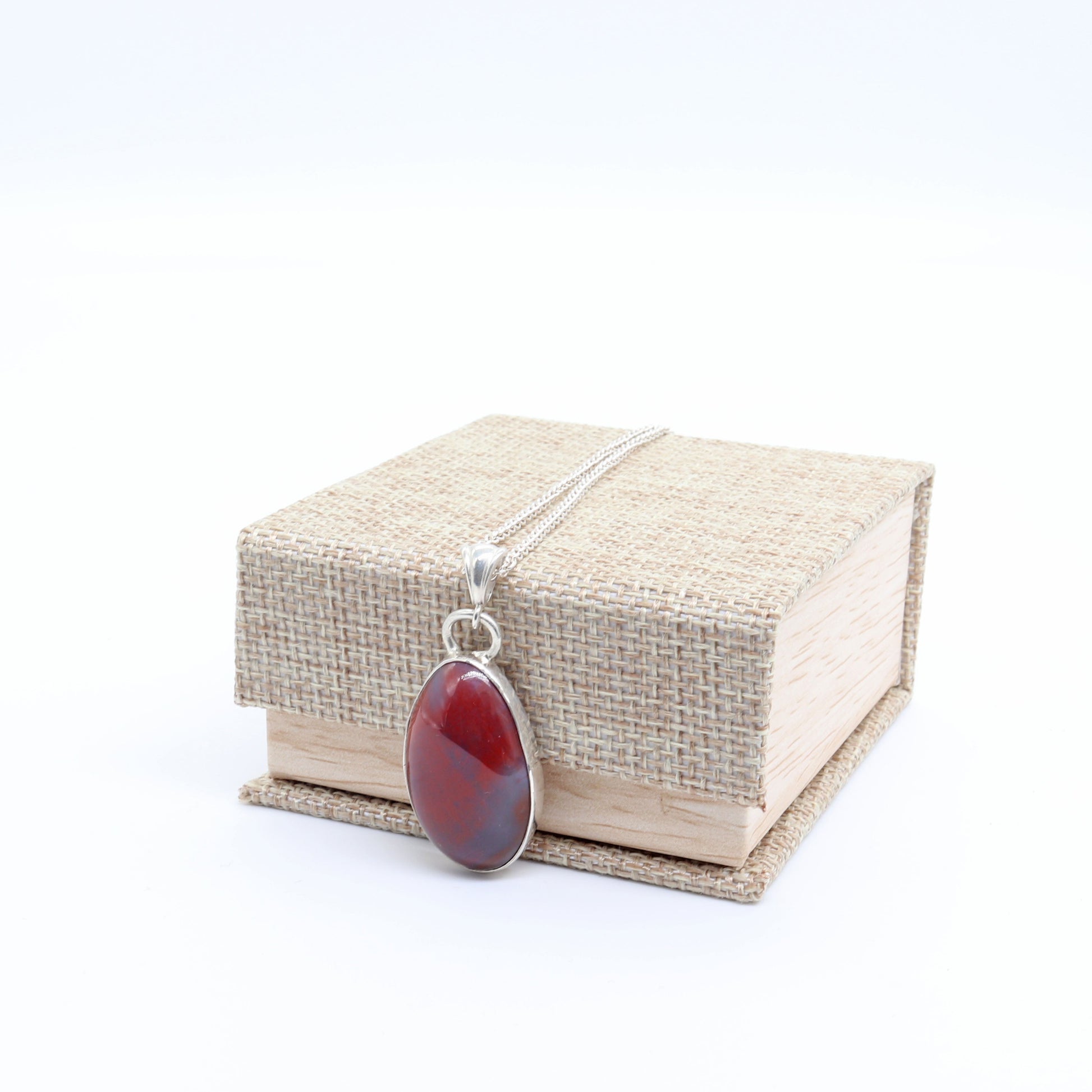 Handcrafted Petrified Rainbow Wood pendant with Argentium 935 Silver bail, 41.48mm next to included gift box.