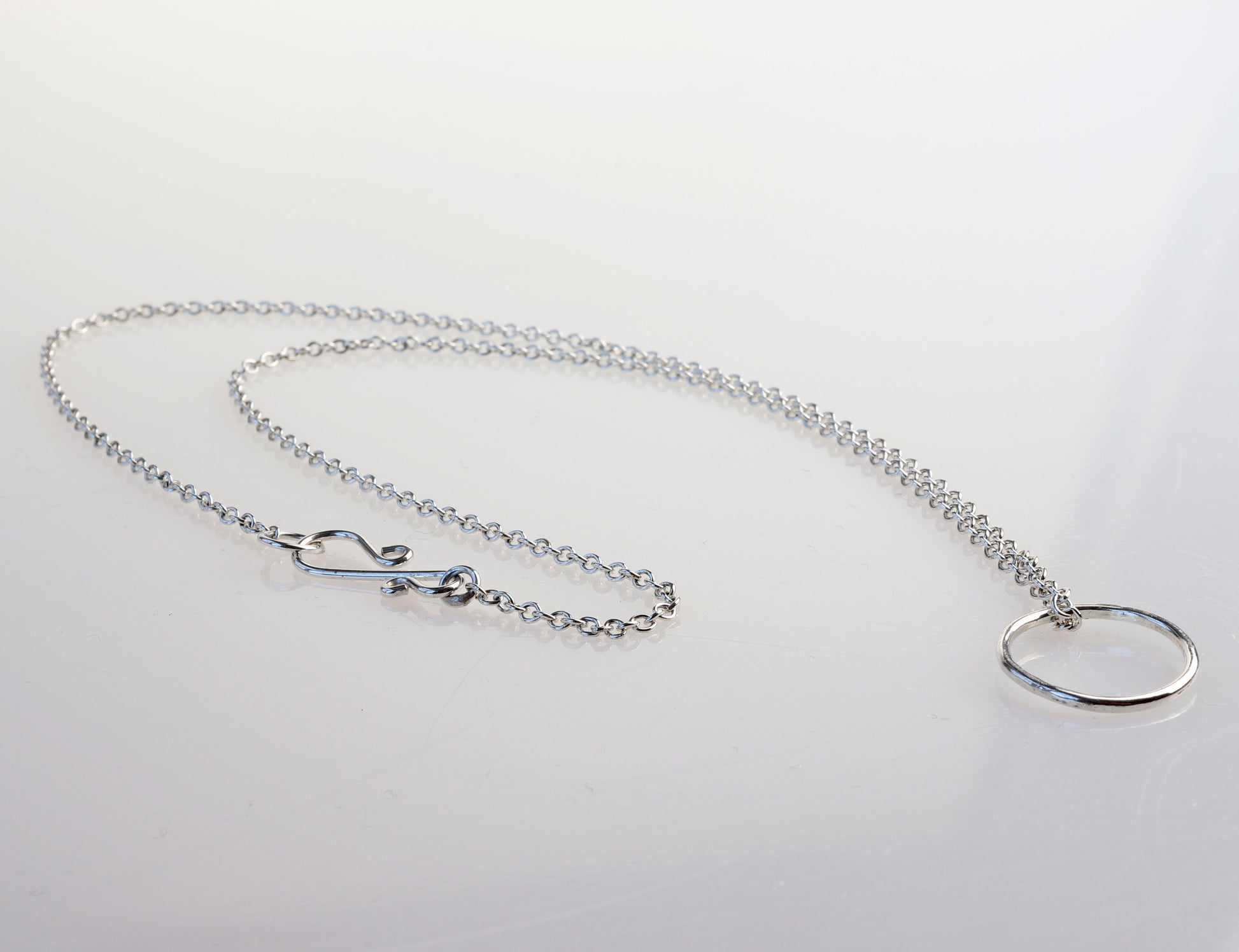 Elevate your jewelry collection with this handcrafted Open Circle Pendant Necklace, made from premium 935 Argentium® sterling silver. This versatile necklace is designed to be worn with or without the pendant and can be personalized with your favorite charms. Known for its hypoallergenic properties, tarnish resistance, and sustainability, 935 Argentium® silver is crafted from 100% recycled materials and has a higher silver content than traditional 925 sterling silver.