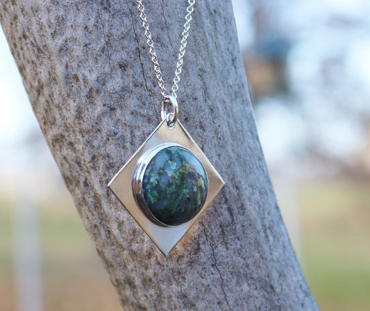Variscite pendant shown hanging against an elk branch.