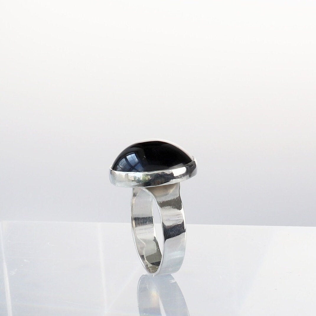 Standing side profile of African Blue Tiger’s Eye ring with polished silver bezel and domed cabochon