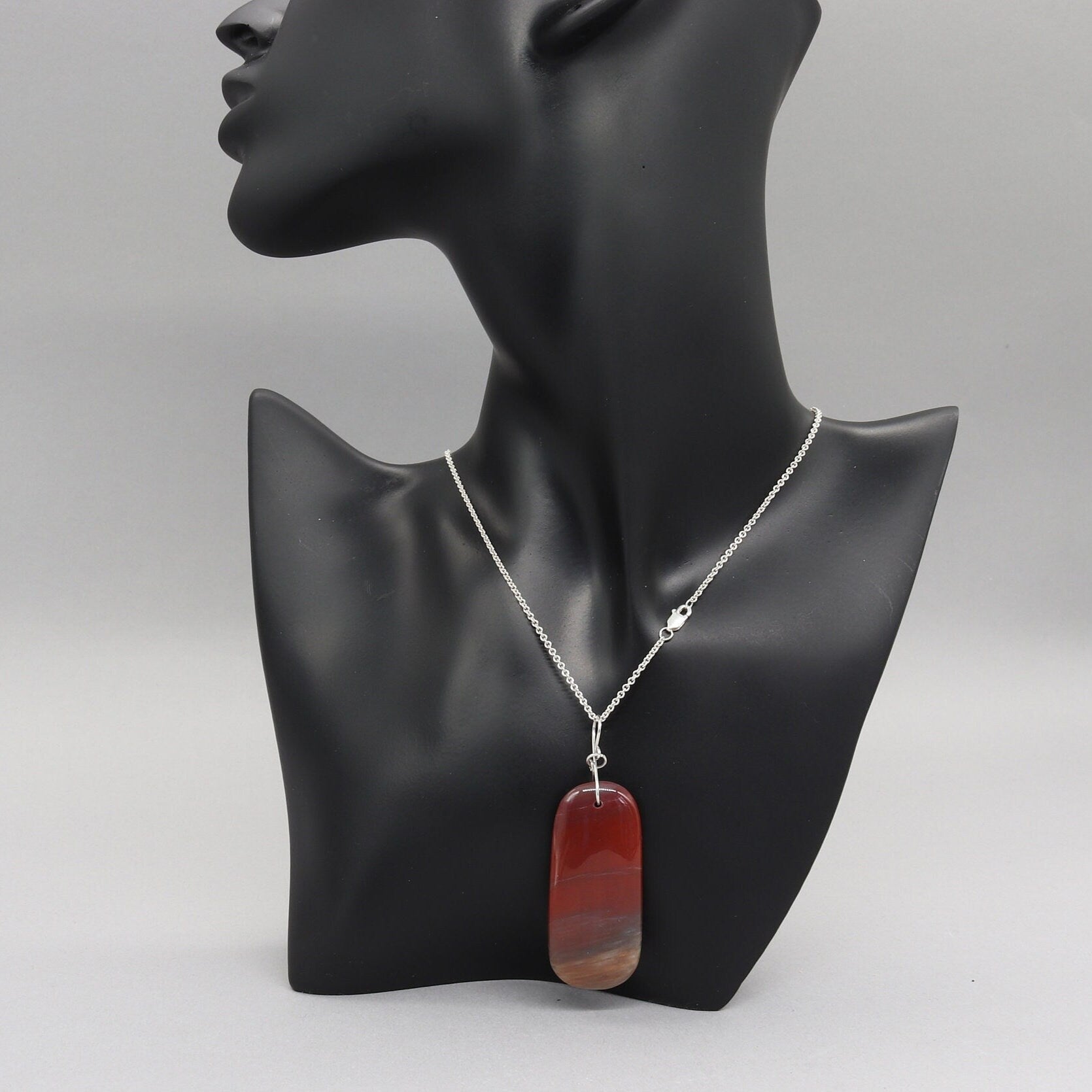 Tag-Shaped Petrified Rainbow Wood Pendant – Handcrafted Focal Piece for Jewelry Making. Displayed on black resin jewelry mannequin.