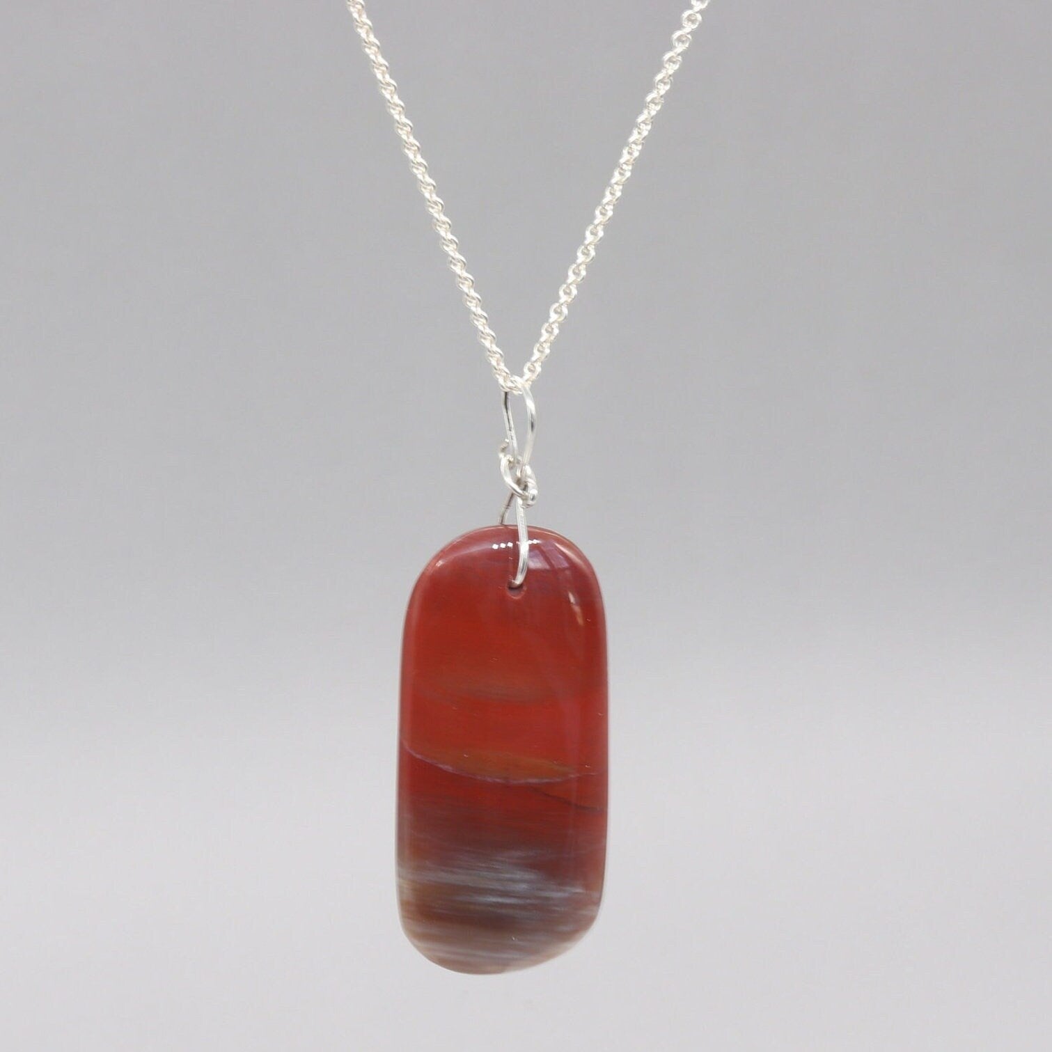A handcrafted pendant with warm terracotta reds fading into soft taupes and golden browns, this natural Arizona Petrified Rainbow Wood displays a subtle gradient that evokes desert landscapes and ancient beauty.