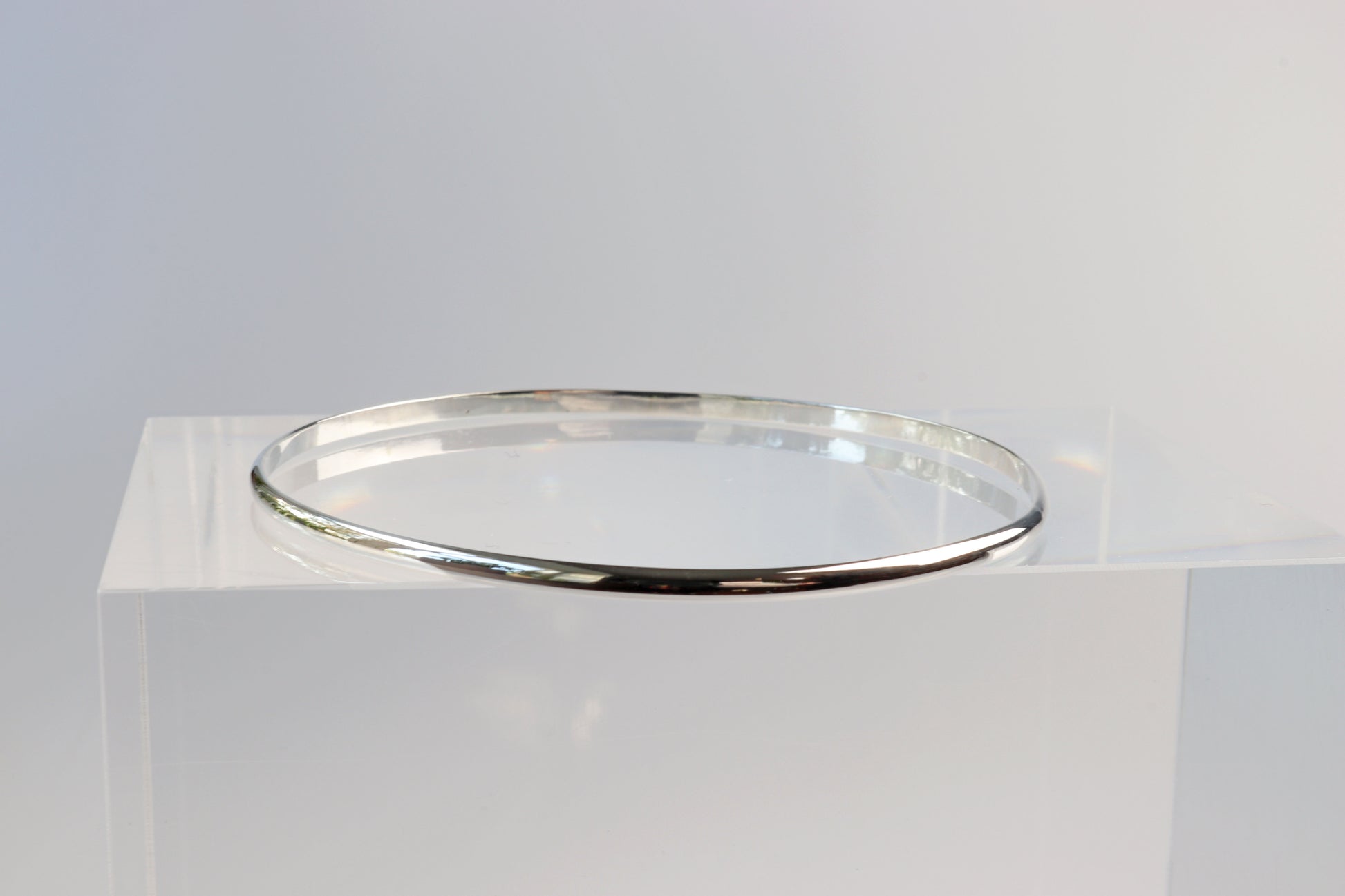 A side view of the silver bangle bracelet with a smooth, polished finish.