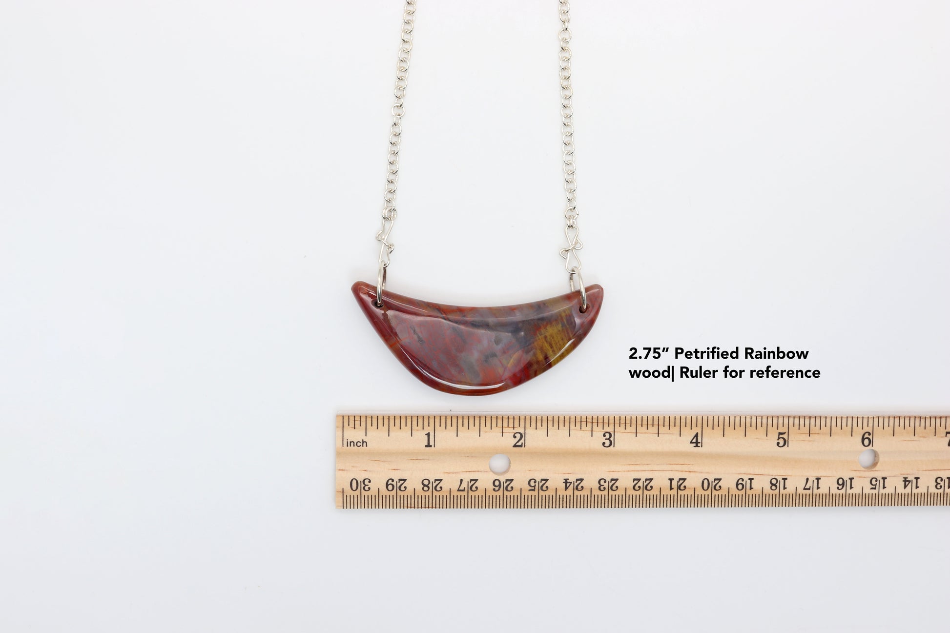 2.75" Petrified Rainbow Wood handcrafted pendant with 935 Argentium Silver attached.  Ruler is for reference on white background.