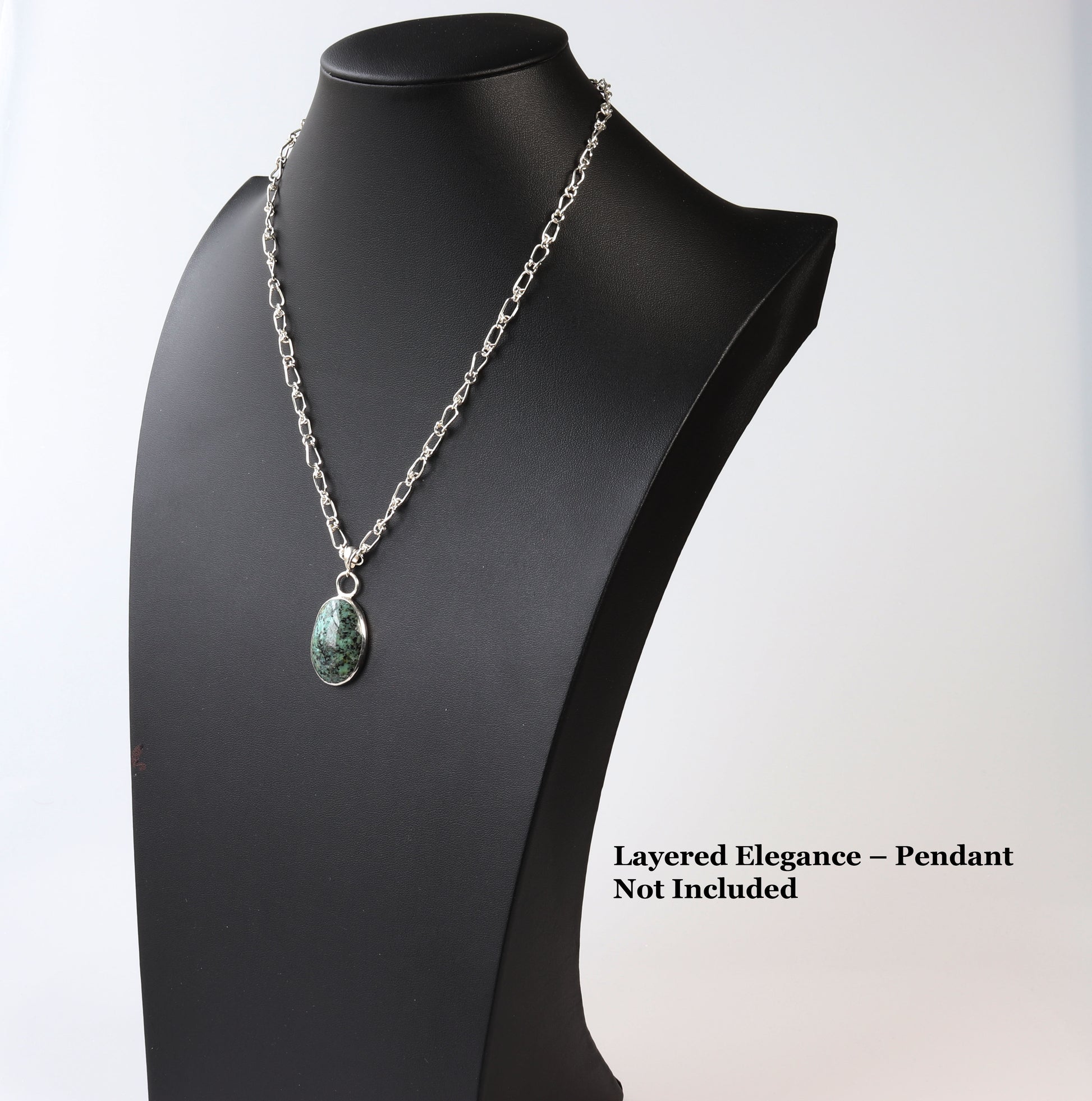 Double-Link Argentium® .940 Silver teardrop Chain Necklace with a turquoise on black mannequin by Elkhorn Silver™, text overlay 'Layered Elegance-Pendant Not Included' in black, light gray background.