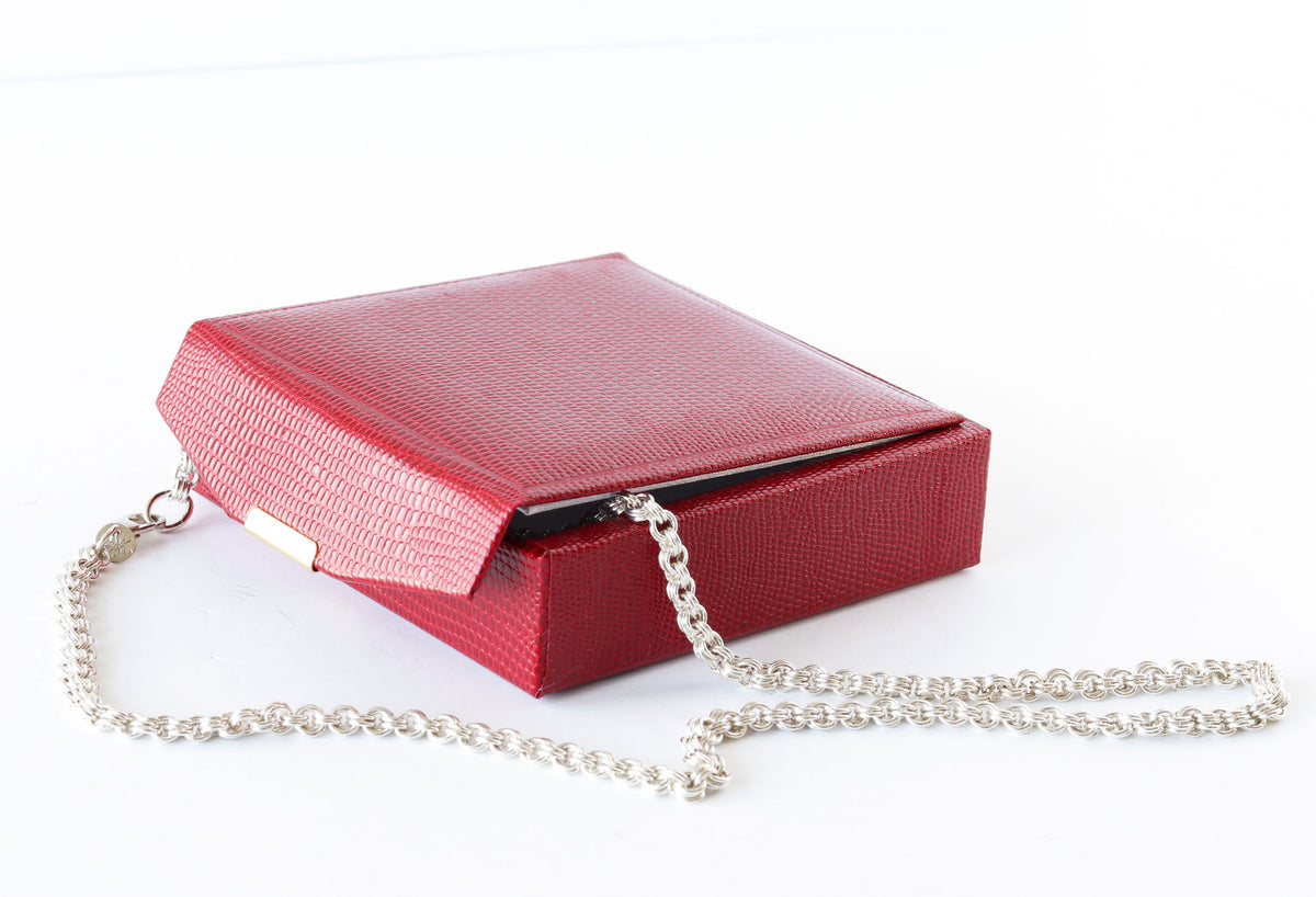 A solid handcrafted Argentium Silver cable chain necklace shown draped inside of a Red faux leather gift box against a white background