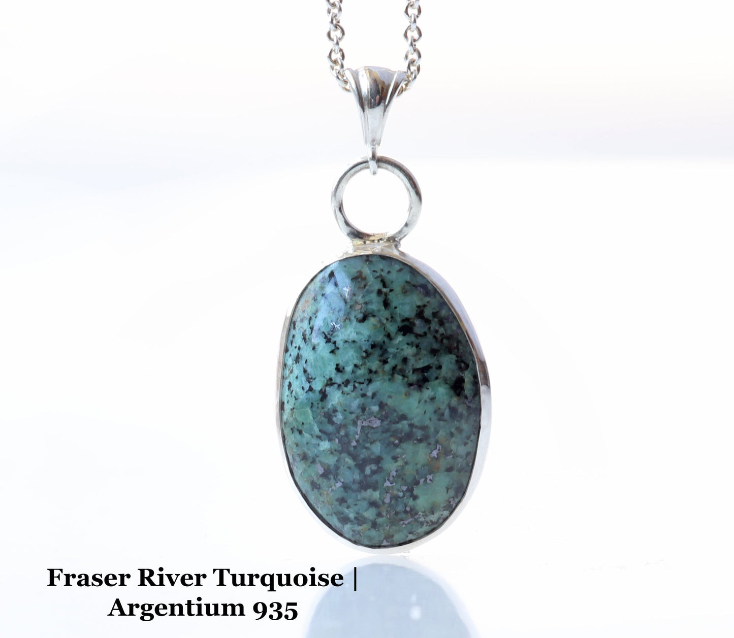 A unique Fraser River Turquoise Pendant suspended from a silver chain. Handcut and polished to showcase the blue-green and black matrix patterns of the stone. Set in Argentium 935 with a .999 pure silver bezel.