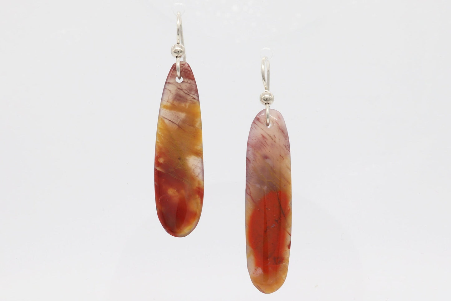 Expertly Handcut and polished Arizona Petrified Rainbow Wood reveals a stunning array of natural reds, oranges, golds, and mauves in these captivating translucent earrings. Accentuating the organic beauty of the wood, the light and comfortable earrings are paired with premium .935 Argentium® Silver ear wires, offering both elegance and a secure, comfortable fit.