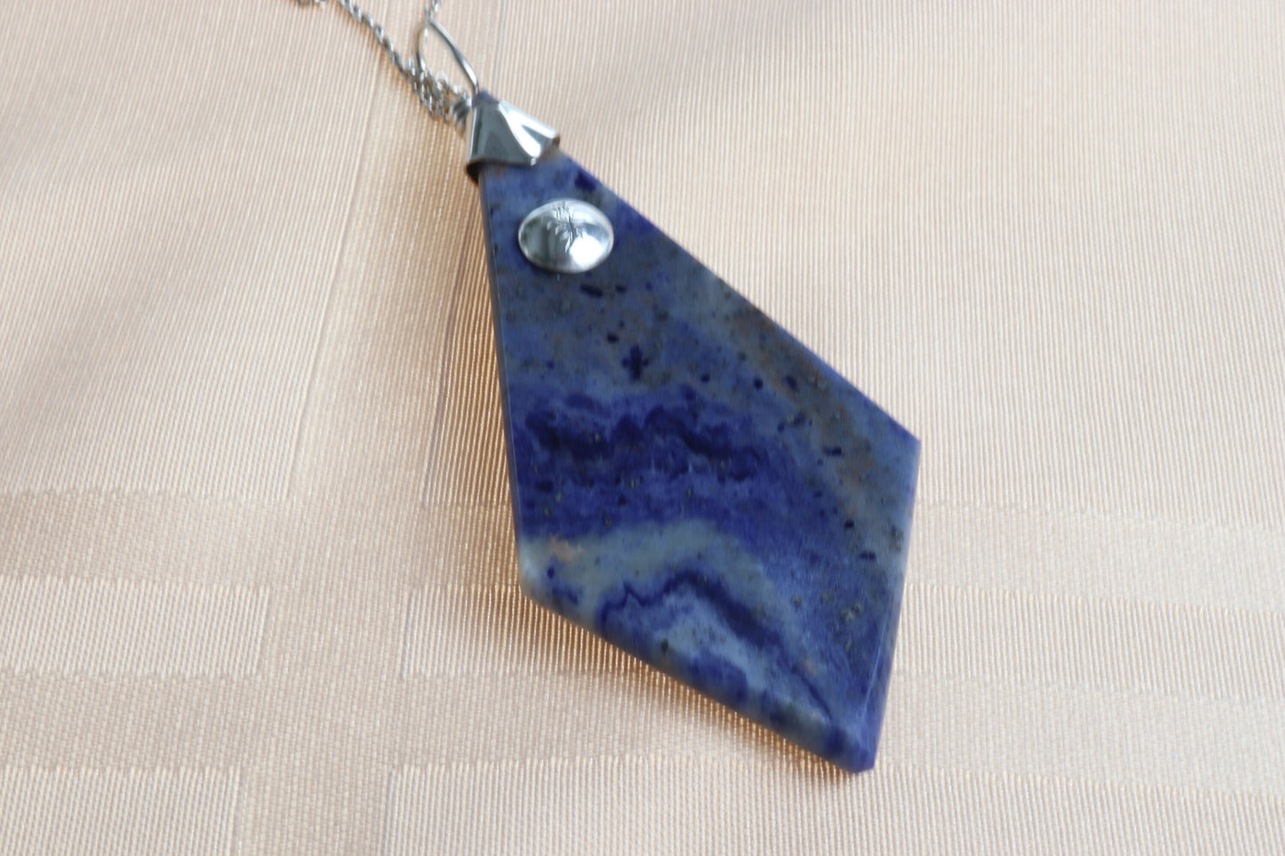 A large 3.23 inch distinctive, rare and remarkable Foidolite igneous rock, expertly cut into a kite shape, polished, and elegantly presented with a custom crafted Argentium® Silver bail setting.