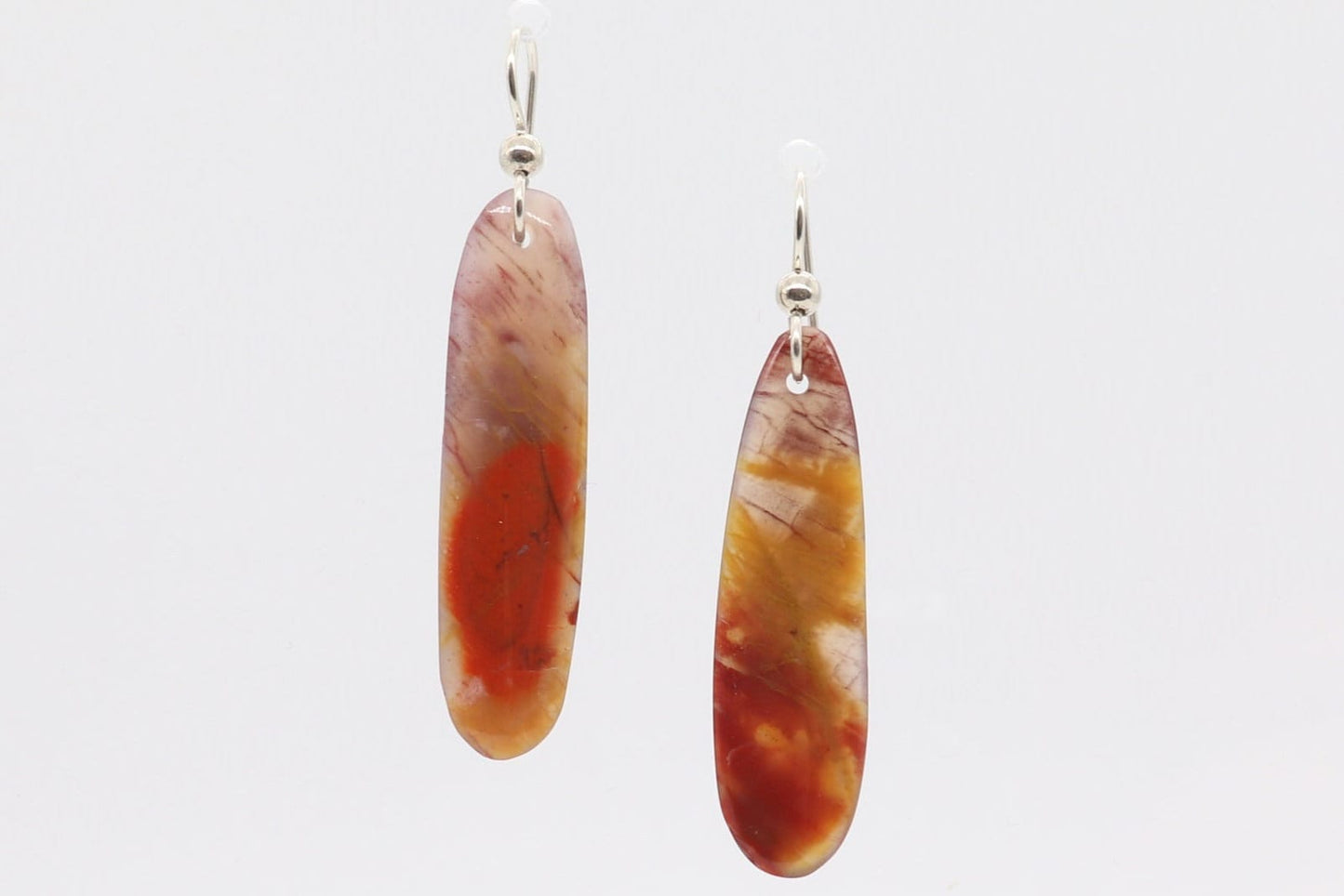 Expertly Handcut and polished Arizona Petrified Rainbow Wood reveals a stunning array of natural reds, oranges, golds, and mauves in these captivating translucent earrings. Accentuating the organic beauty of the wood, the light and comfortable earrings are paired with premium .935 Argentium® Silver ear wires, offering both elegance and a secure, comfortable fit.