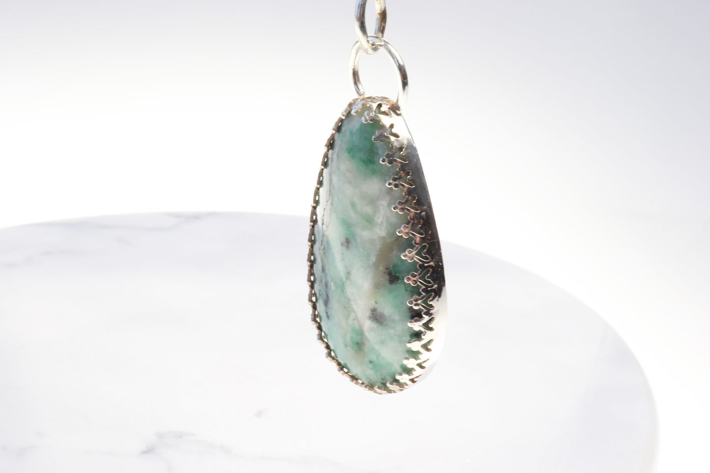 A natural 2.12 inch African Turquoise gemstone, handcut and polished in our Missouri studio to reveal its earthy patterns and hues of teal, green and creamy white. Reminiscent of real turquoise, this African Turquoise gemstone boasts its own unique patterns and variations, making every piece truly one-of-a-kind. Set in a custom 935 Argentium setting paired with a complementary 18 inch chain.