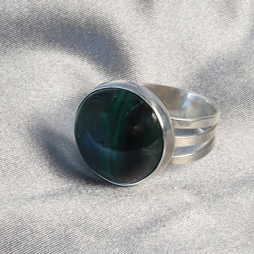 A handcrafted one-of-a-kind cabochon Malachite gemstone men's ring, handcut and polished in our Missouri studio. The ring is crafted from fine silver, and sterling Argentium® 935 Silver renowned for its resistance to tarnishing and its durable quality.