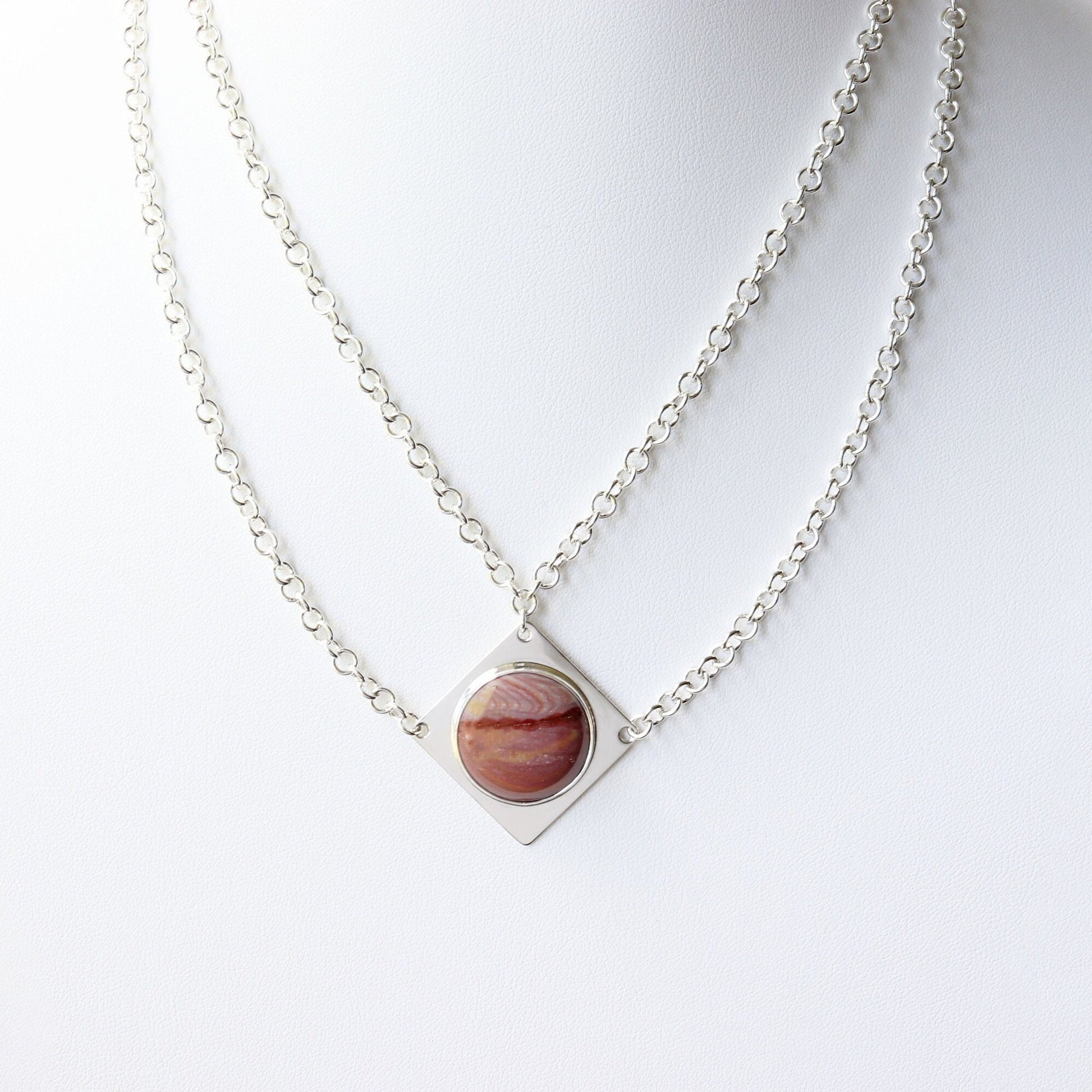 Handcrafted in our studio is a uniquely elegant creation: the Petrified Rainbow Wood Pendant set in sterling Argentium® 935 Silver, accompanied by a custom dual cable chain necklace with S hook Clasp for easy wearing.