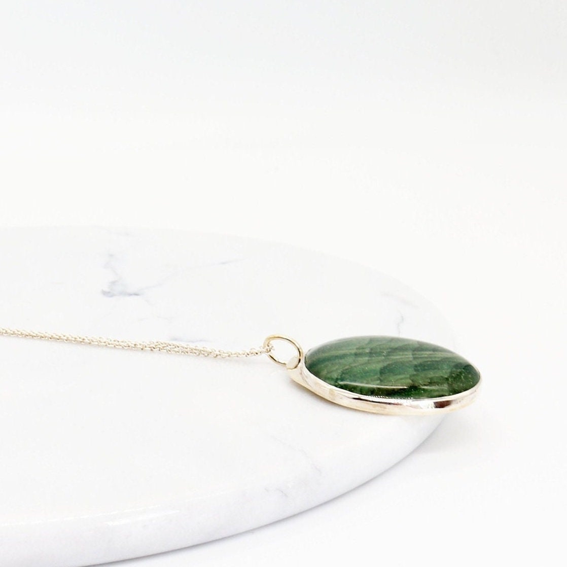 Introducing our handcrafted 1.88 inch Arizona Green Lizard Gemstone Pendant Necklace, in Sterling 935 Argentium Silver. The gemstone was handcut and polished (in our Missouri Studio) into a smooth cabochon to showcase the stunning green hues and natural patterns of the stone. To complete the look a complementary sterling 935 Argentium chain is included.