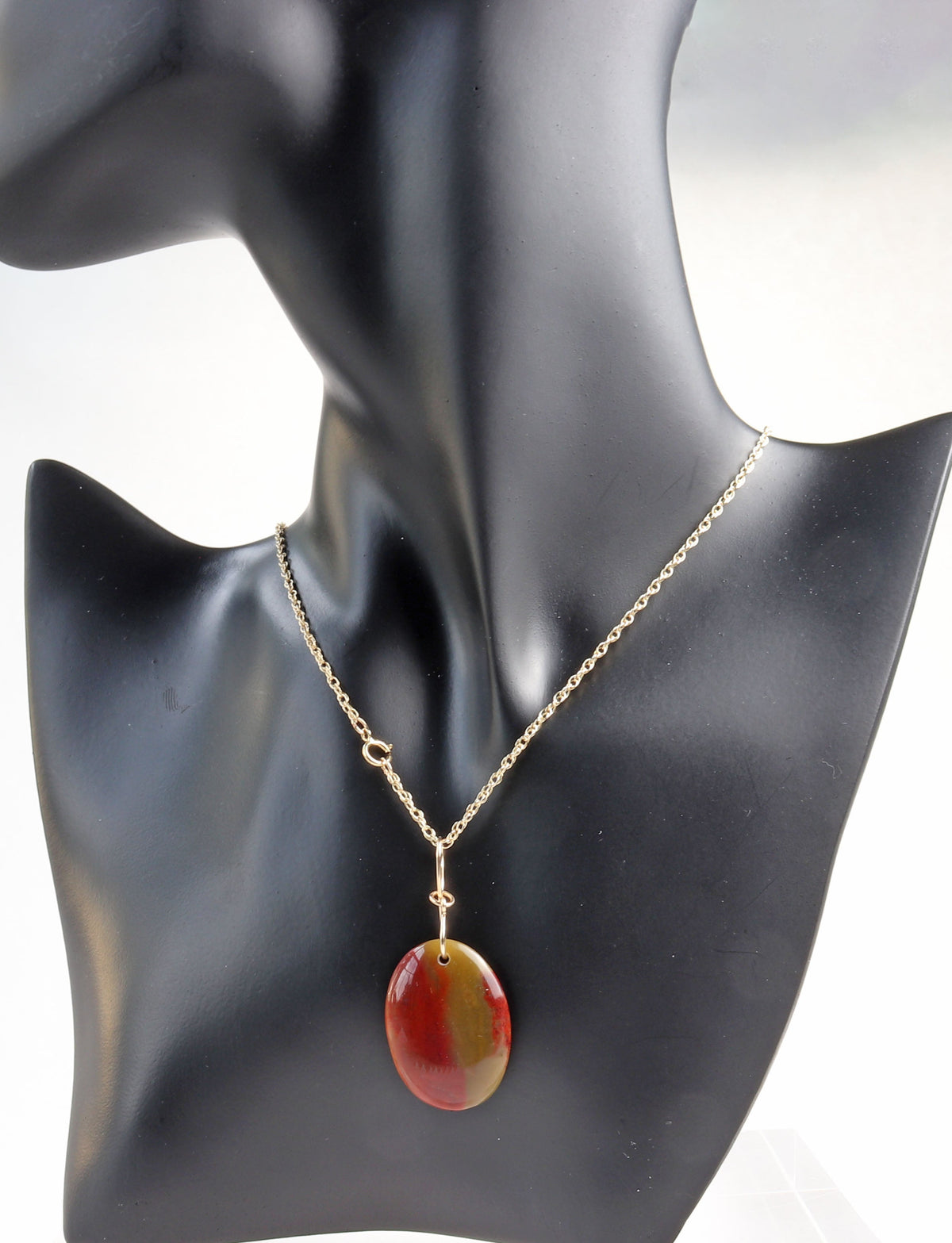 A 14/20 gold rope chain necklace with a polished Sonoran sunrise with rich red cuprite and warm golden tones, displayed on a black mannequin bust against a white background.