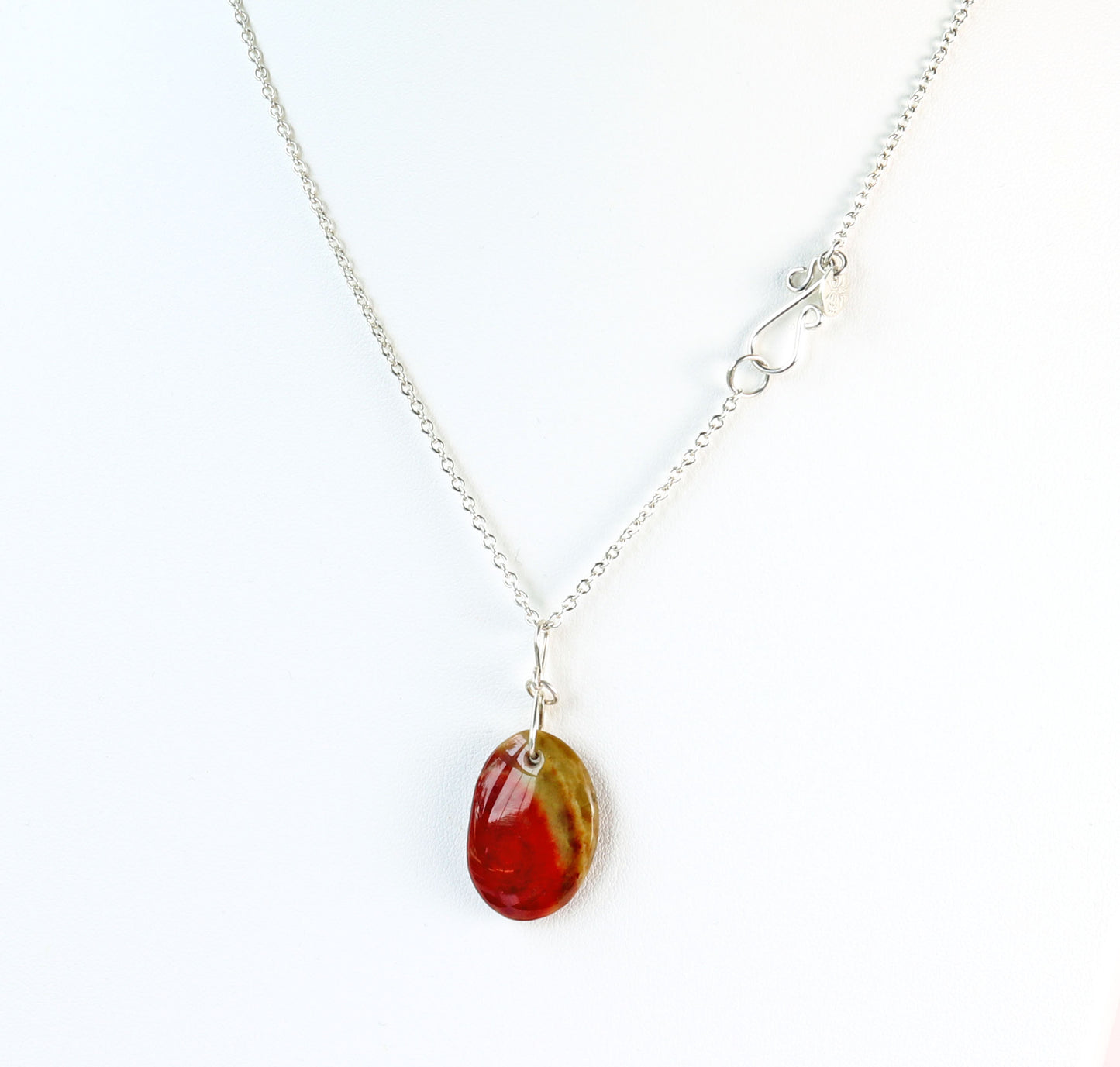 Necklace with a oval-shaped sonoran sunrise green and red pendant on a white background