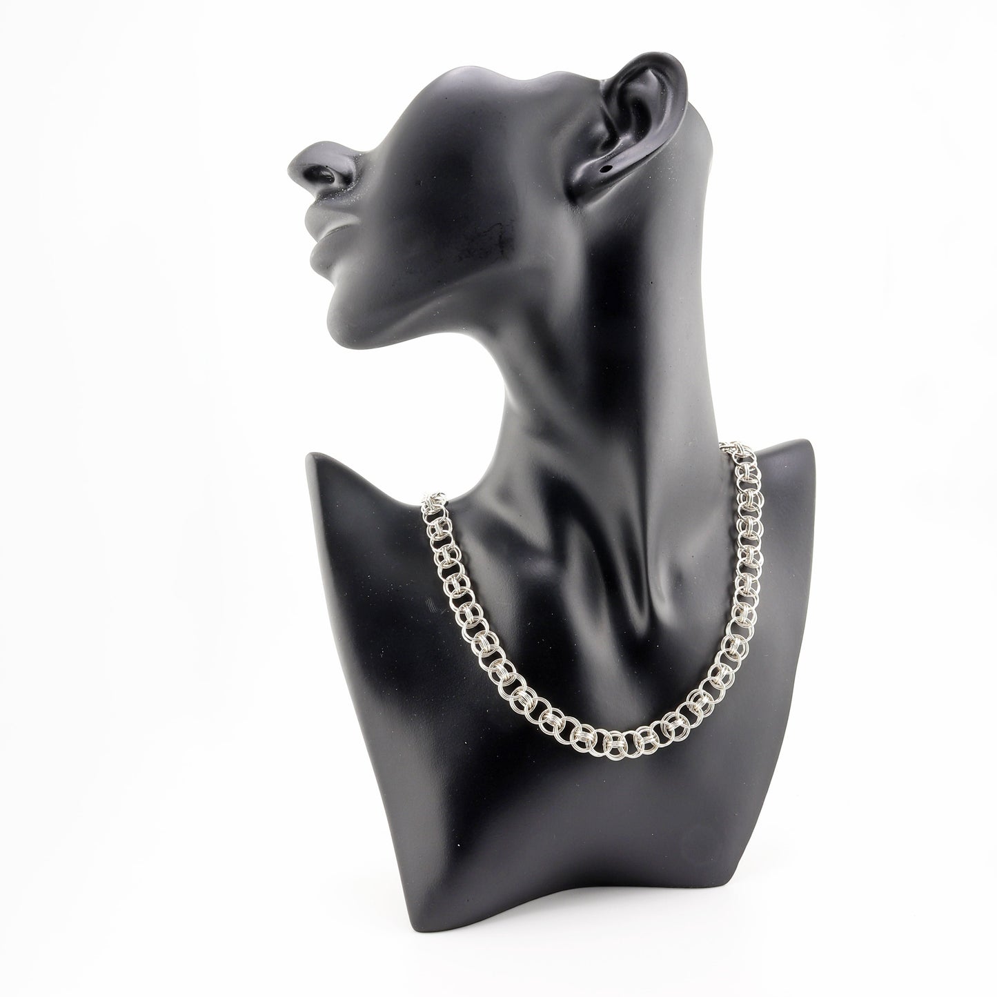 Black resin jewelry boutique mannequin modeling 18-inch Argentium silver helm weave necklace against white background.
