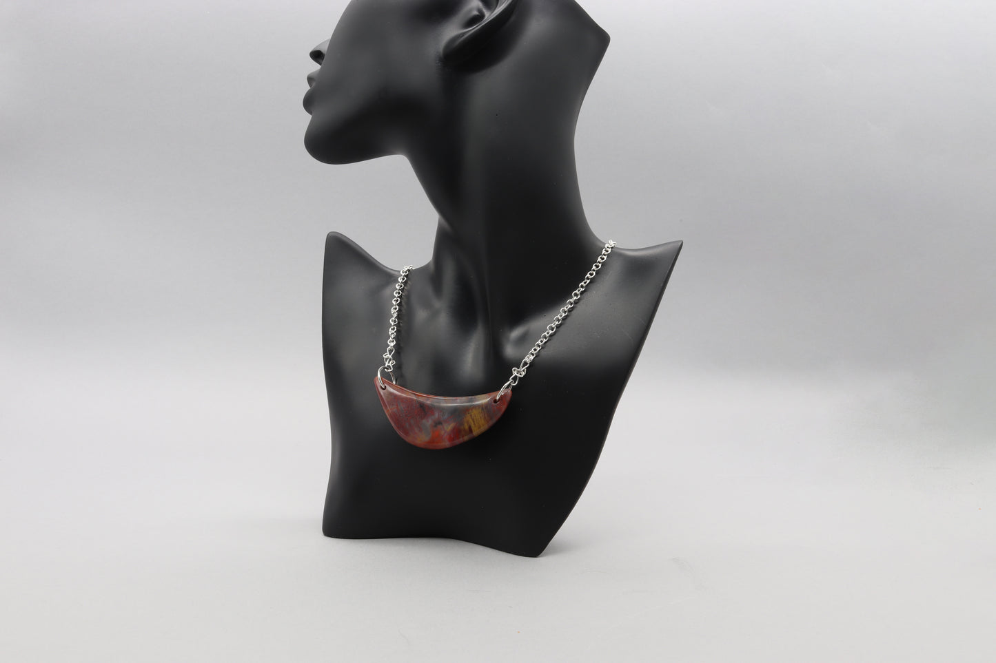 A piece of Arizona's history in this stunning sterling Petrified Rainbow Wood crescent moon pendant. Handcrafted with sterling Argentium® Silver 935 bow shaped dual wire bails and single cable chains. Handcut and polished into a moon shaped crescent to reveal the remarkable translucent colors and patterns of nature's artistry on both sides of the pendant.