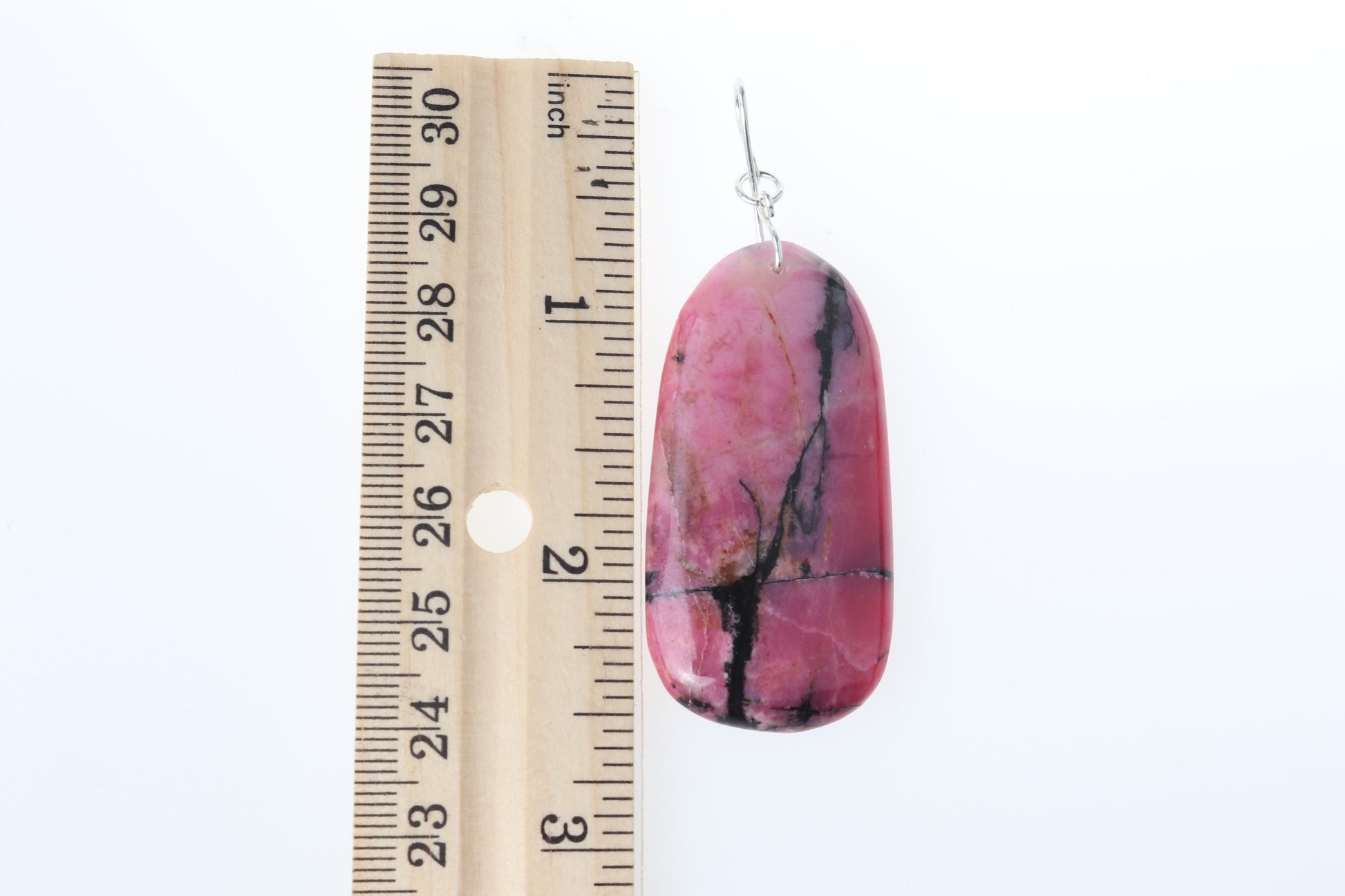 2.5" A polished Rhodonite pendant on both sides and features a handcrafted infinity bow-shaped bail made from hypoallergenic, tarnish-resistant Argentium® 935 silver.  Shown next to a ruler to illustrate the length of the pendant.