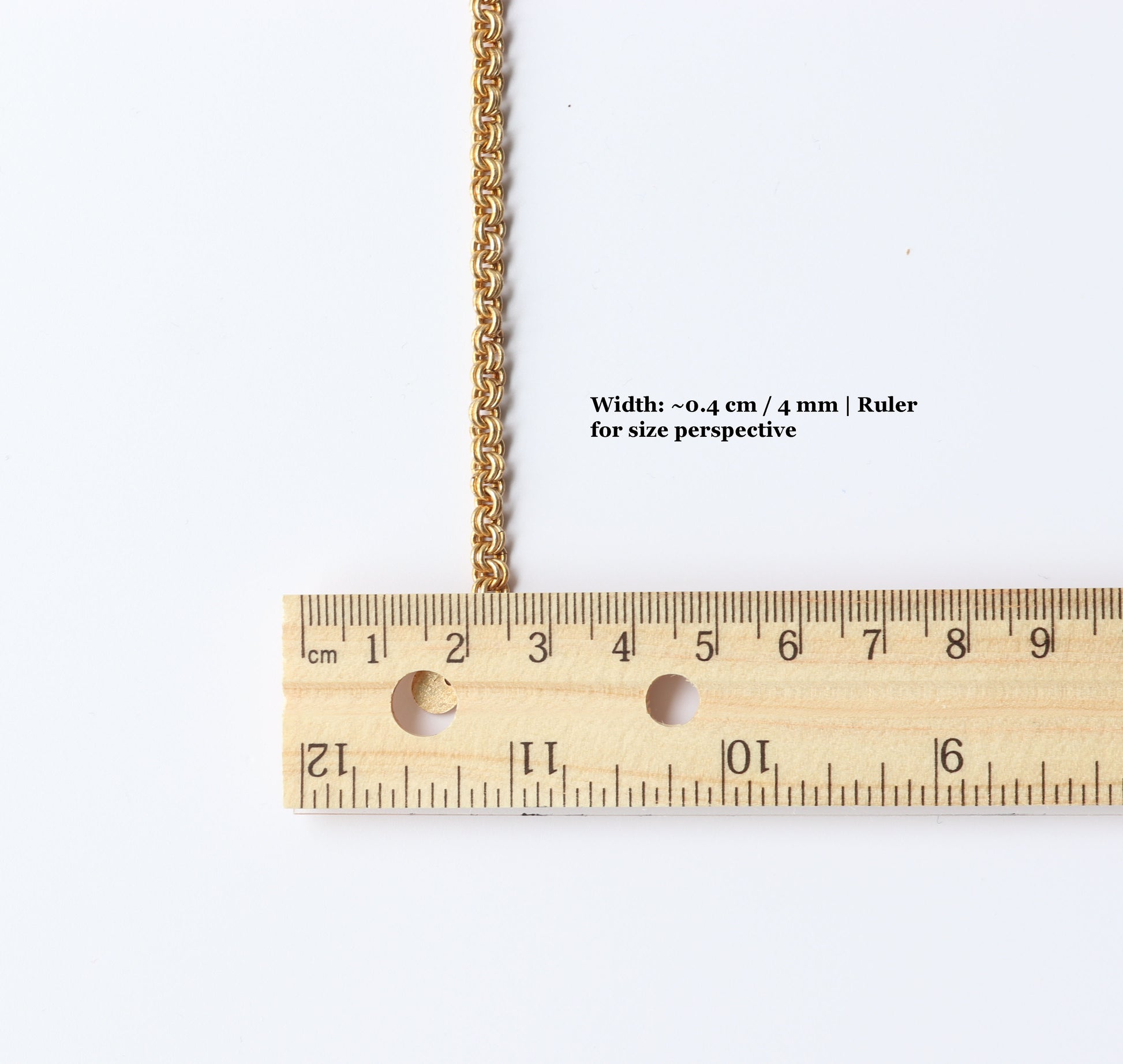 Ruler next to brass chainmail bracelet showing the width of 0.4 cm or 4mm. Ruler shown for size perspective.