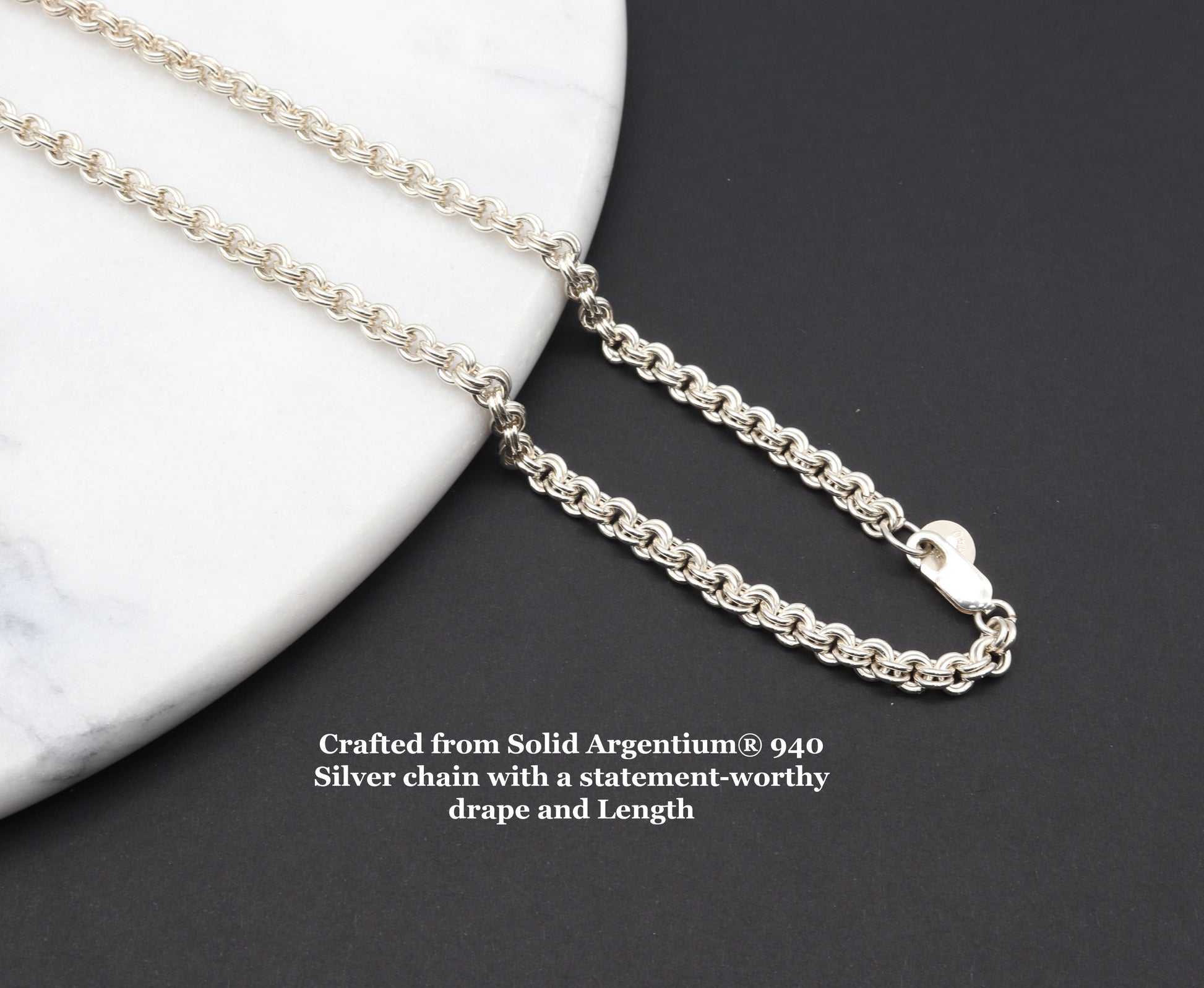 An Argentium® 940 solid Silver Double-Link Chain - Choose your Clasp with 24 inch length.  Shown draped on white marble slab on black background with text overlay Crafted from Solid Argentium® 940 Silver chain with a statement-worthy drape and Length.