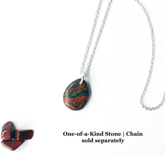 Red Brecciated Jasper pendant. Hand-cut, and polished both sides to showcase a mosaic of deep red tones, earthy browns, and black veining. Delicate quartz or chalcedony veins are visible within the stone—adding subtle shimmer and enhancing its layered, brecciated structure.