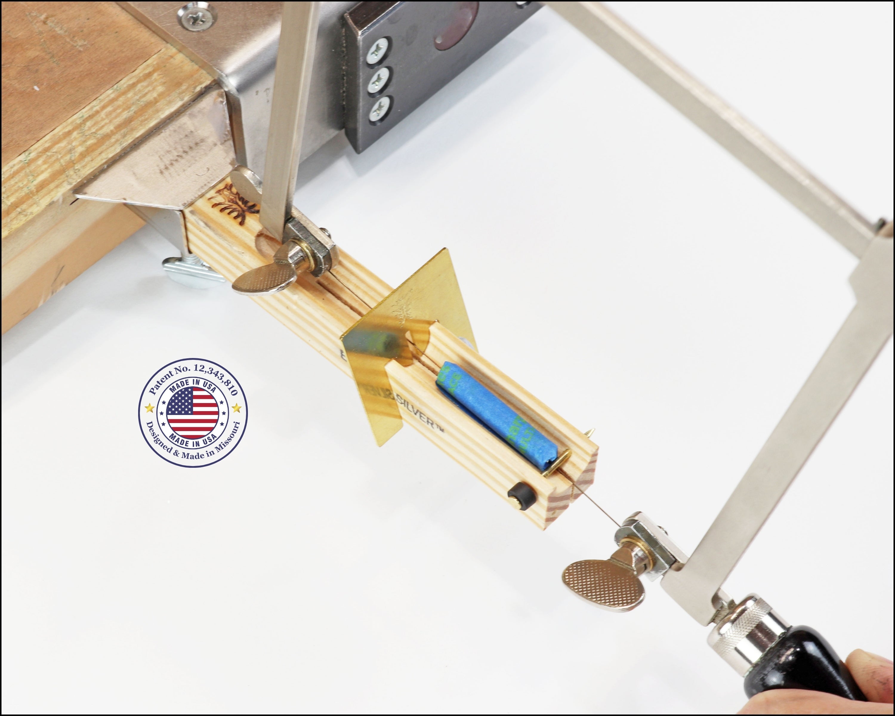 Close-up of a jump ring cutting jig with an American flag patent logo badge in the corner.