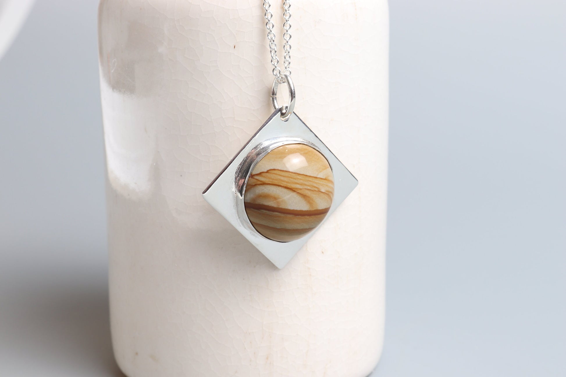 Crafted in our studio is this hand-cut and polished one-of-a-kind Picture Jasper cabochon with a beautiful landscape pattern and color bands set in a unique four-point diamond-shaped of sterling Argentium® 935 Silver paired with a complementary sterling Argentium 935 chain.