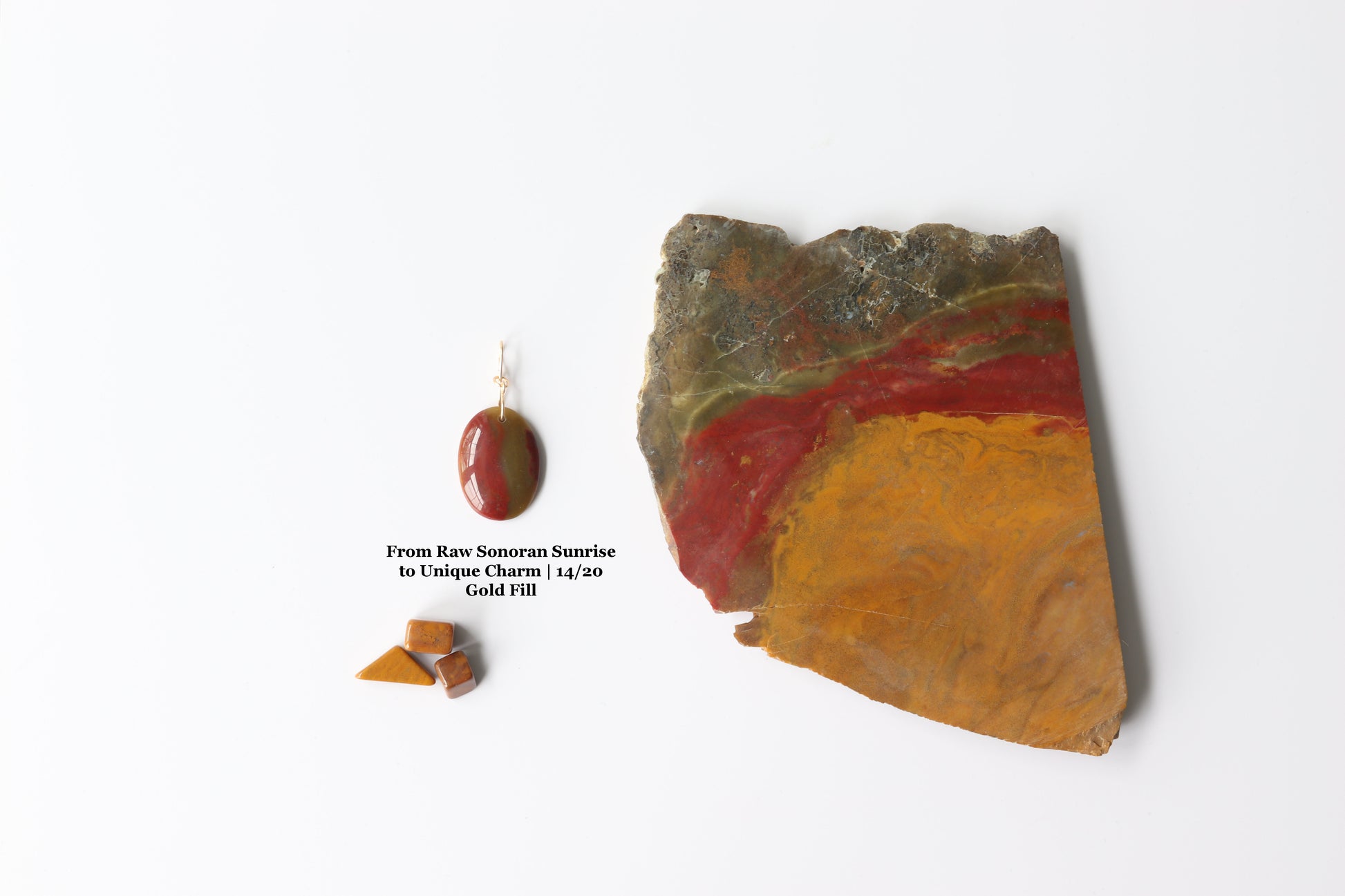 Raw Sonoran Sunrise stone alongside finished pendant showing natural deep red cuprite, ochre, and chartreuse tones transformed into a hand-polished, one-of-a-kind charm.