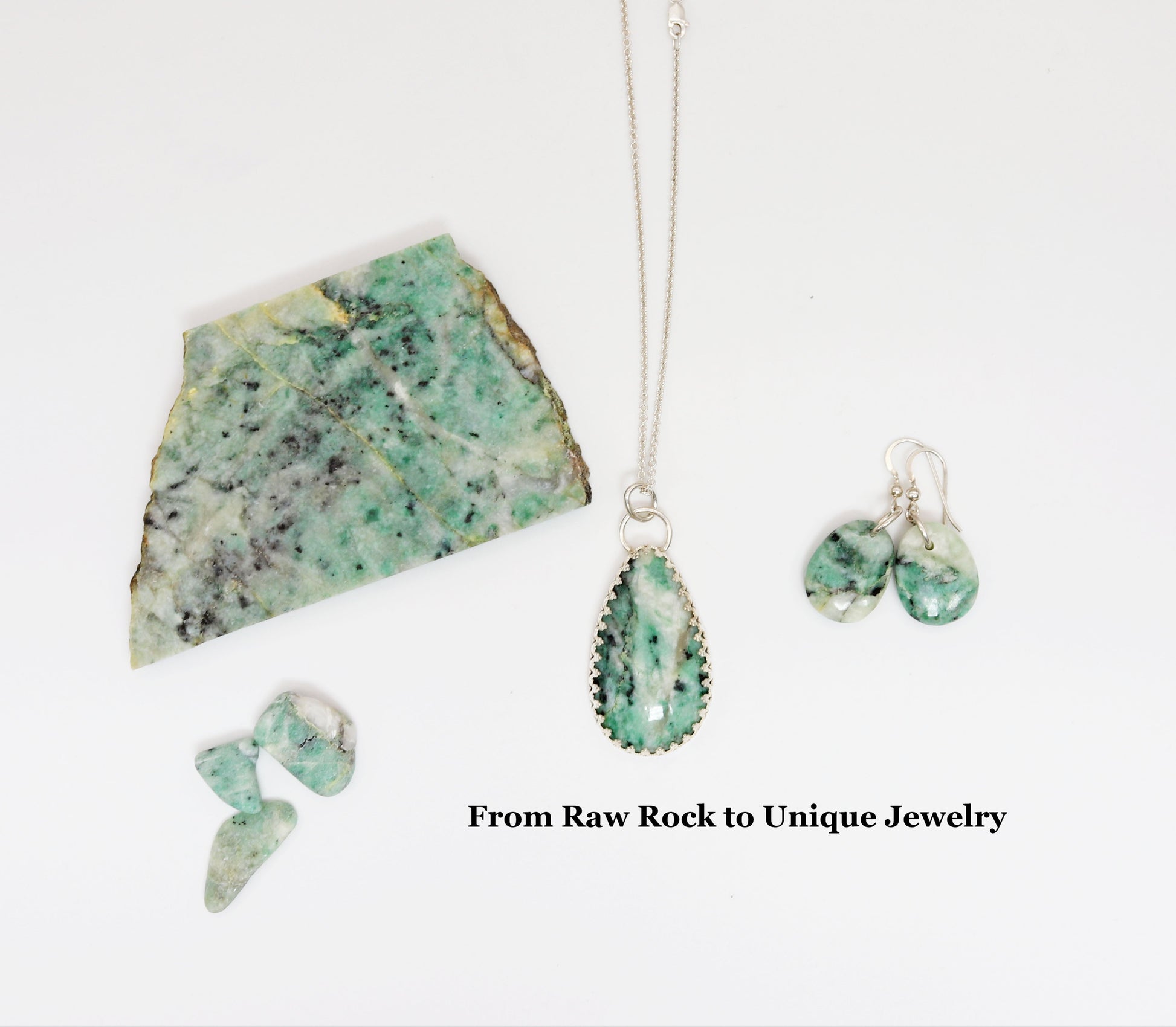 A Raw African Turquoise on white background shown with the finished pendant and earrings along with small pebbles of African Turquoise.  The display is to illustrate the craft rock to finished pieces.