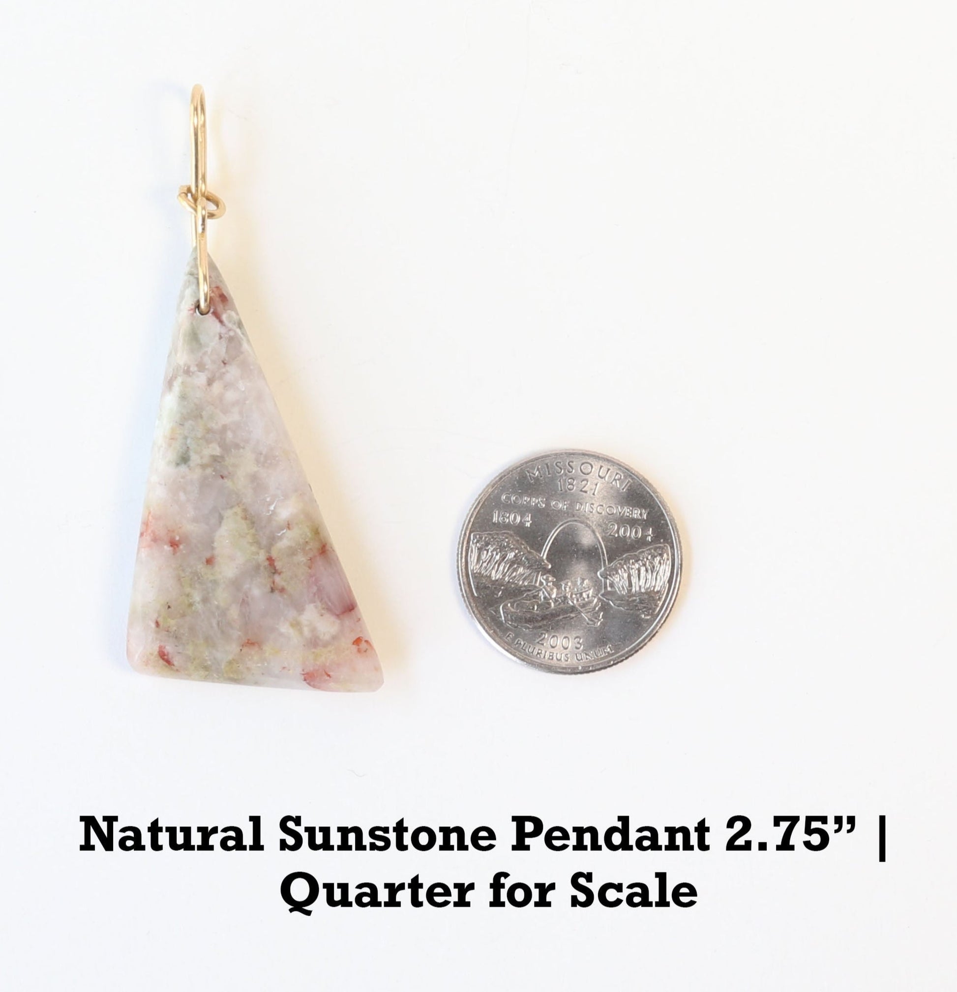 A 2.75 inch Sunstone Pendant hand cut and polished on both sides to showcase the unique  blend of earthy reds, muted greens, and translucent swirls of gray and creamy white of earthy elegance.  This one-of-a-kind irregular triangle shape adds bold character to wire-wrapped jewelry, mixed-media designs, or statement necklaces.  Shown with quarter for scale.