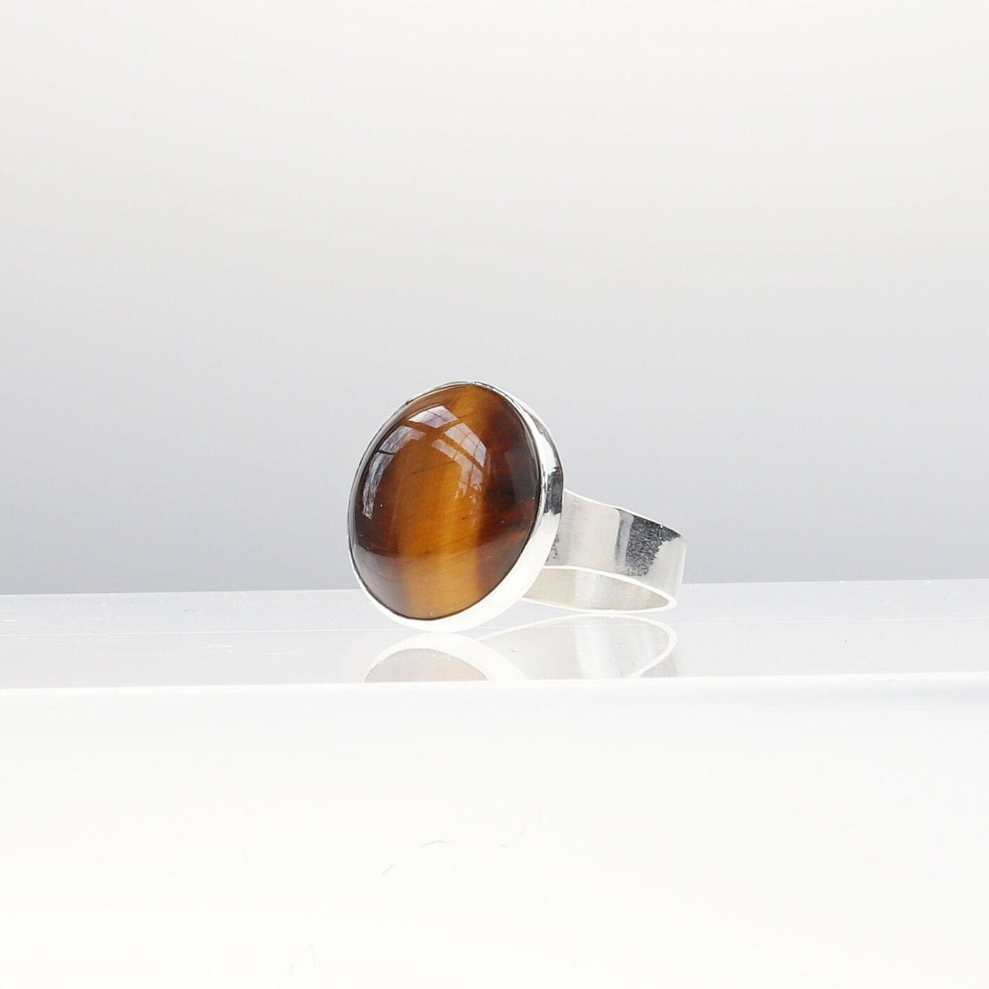Tiger’s Eye ring in Argentium® 935 Silver, size 11.75. Features round handcut cabochon with golden chatoyancy.