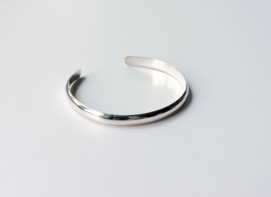 A Silver Cuff bracelet handcrafted in solid Argentium® 935. The gently curved low dome profile gives this cuff its sleek, modern look, while the open design allows for slight adjustability.