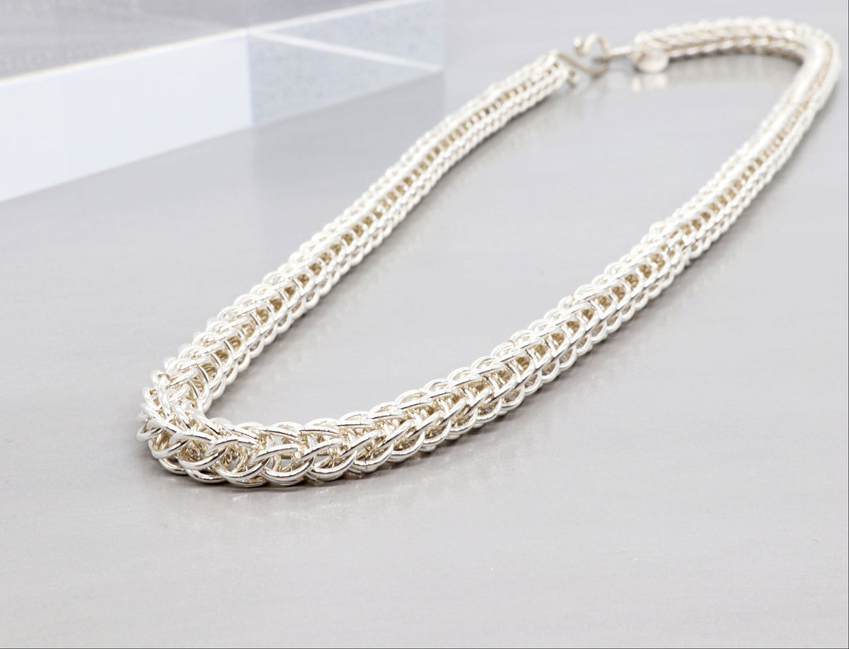 An Argentium persian weave chain necklace with a textured, woven or braided link pattern, displayed on a neutral gray surface.