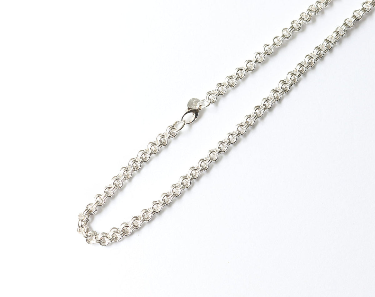 A solid handcrafted Argentium Silver cable chain necklace closeup  on a white background featuring teardrop lobster clasp.