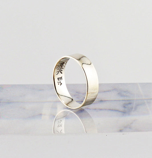 Argentium Silver ring with engraved design on a marble surface