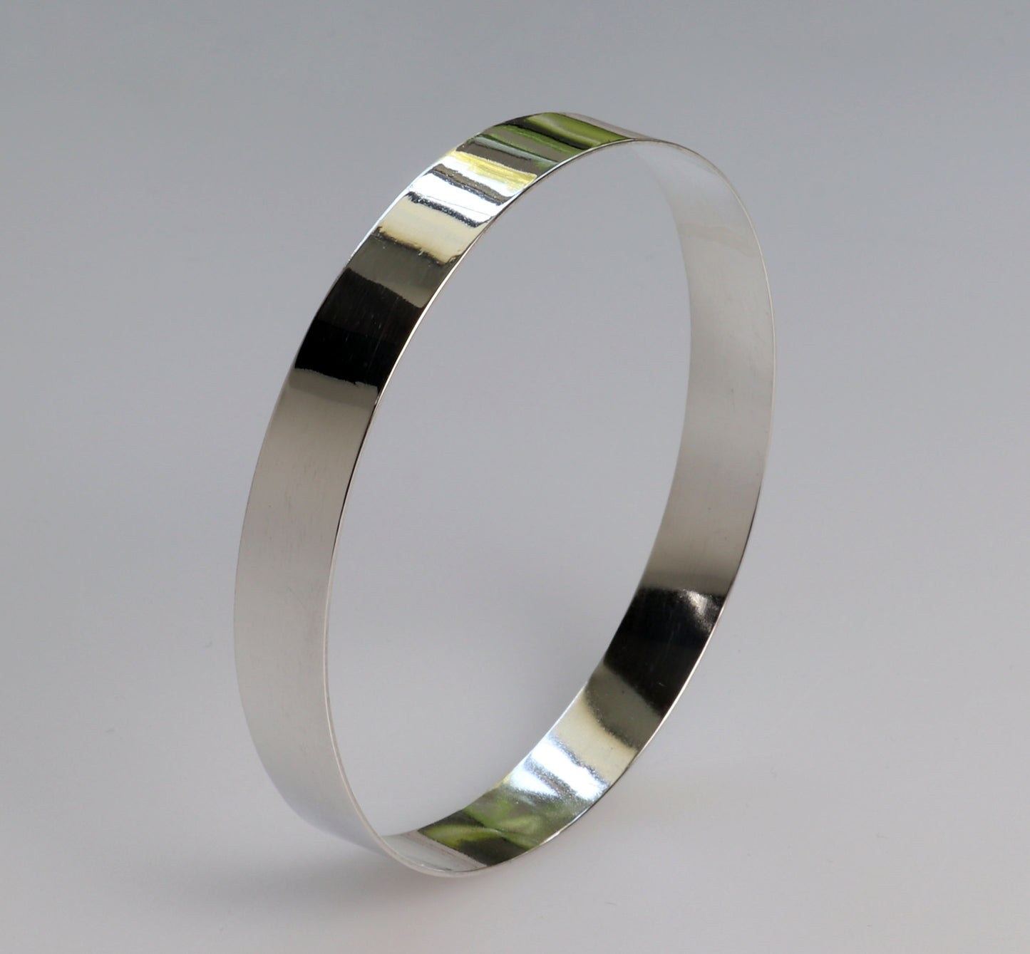 Bangle bracelet in Argentium silver shown against light gray background.