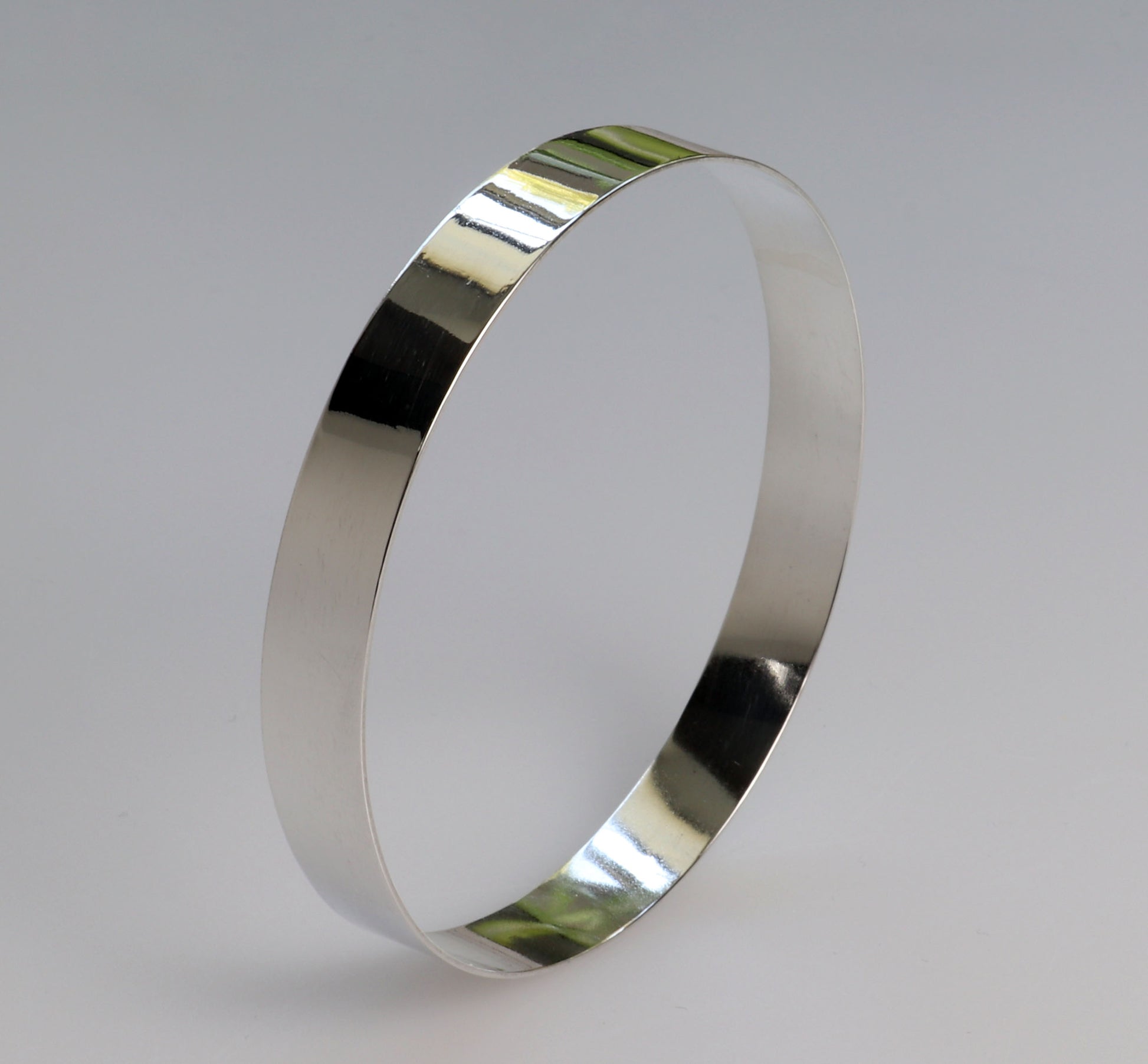 Bangle bracelet in Argentium silver shown against light gray background.