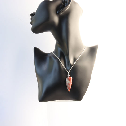 A Crazy Lace Agate arrow shaped gemstone pendant. 
Handcut and freeform polished on both sides to reveal the unique swirling patterns and vibrant mauve deep reds and gray hues. Wear with complementary chain included or with you own favorite necklace.