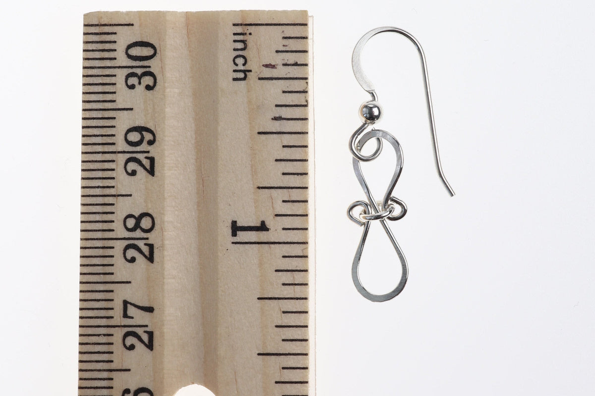 Infinity Bow Shaped Earrings, shown next to a ruler for size and the Drop length of earrings is 1.625 inches on white background.