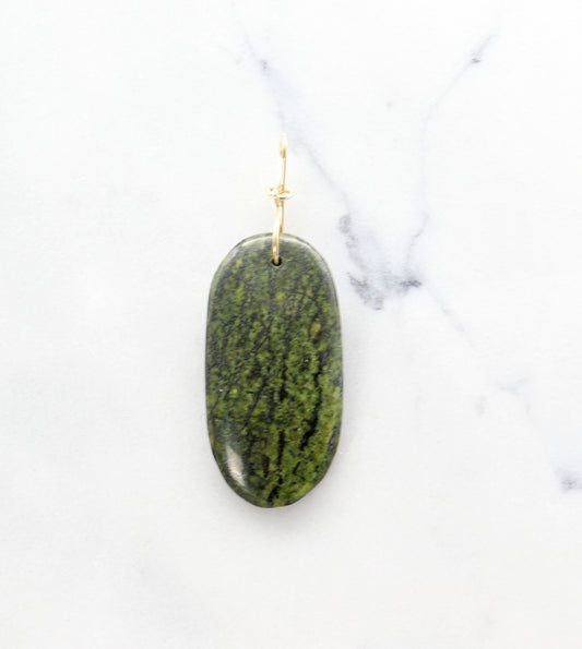 Forest Green Jasper with gold loop on a white marble surface.