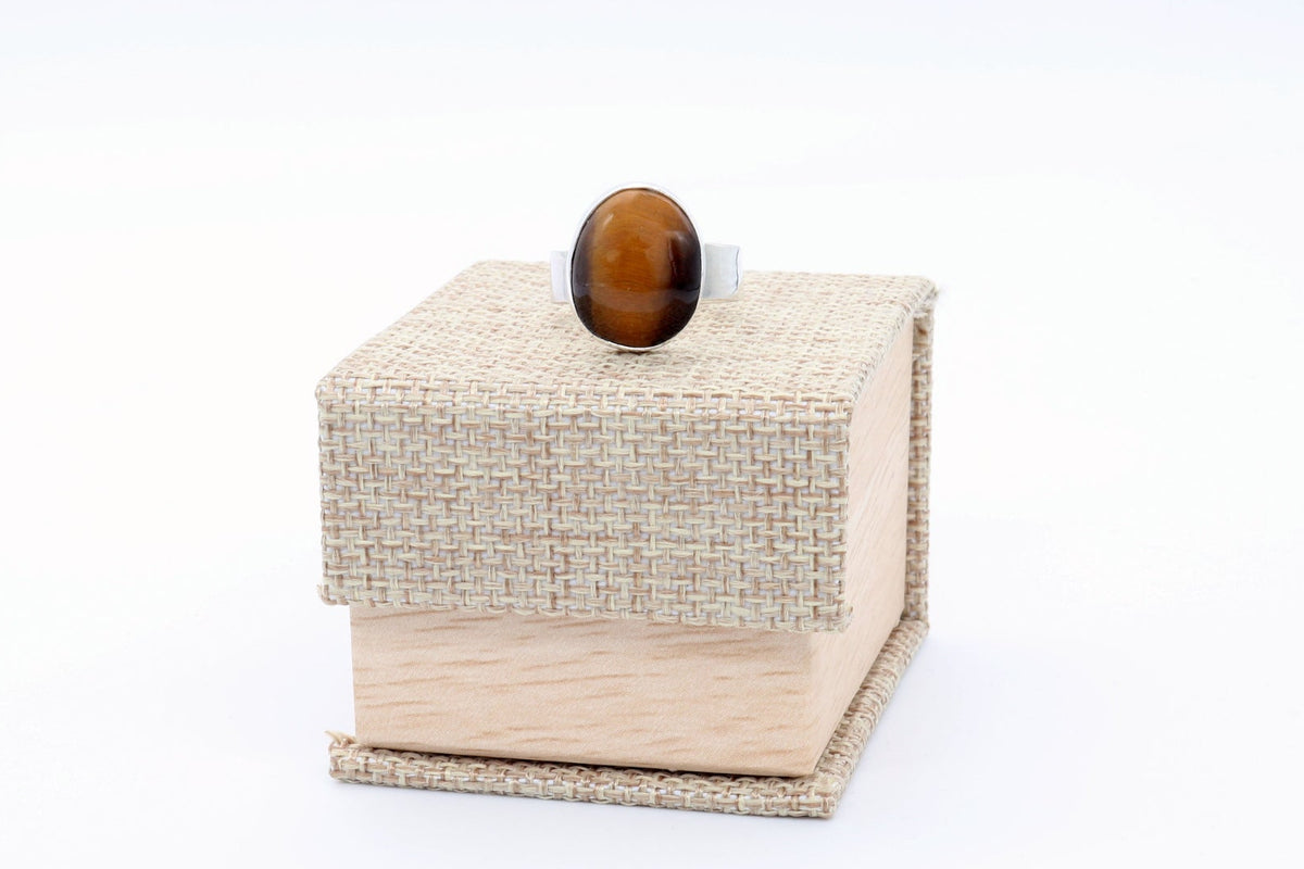Natural Tiger's Eye ring in solid Argentium 935 silver, shown on top of a canvas gift box