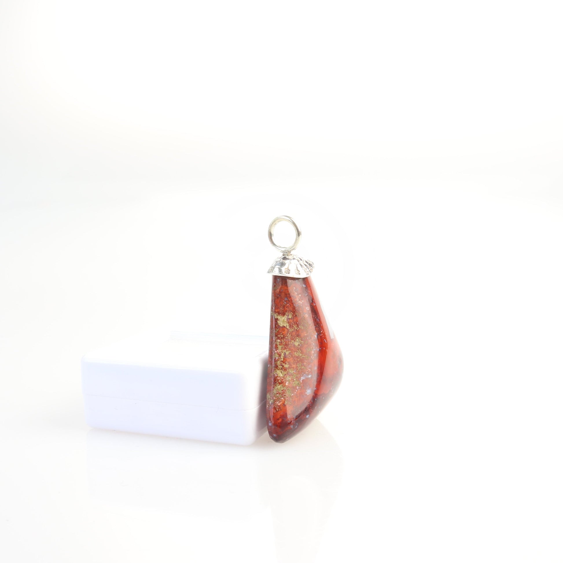 A 1.81 inch Red Jasper Agate Pendant, handcrafted in our small town Missouri studio. Handcut and freeform polished on both sides, showcasing the captivating patterns and rich red hues of this reversible piece. The custom crafted bail in sterling 935 Argentium Silver adds a touch of elegance. To make this piece ready to wear, a matching 1.7 Argentium silver chain is optional with gift box. This pendant could be used as a focal piece for your next beading project. 