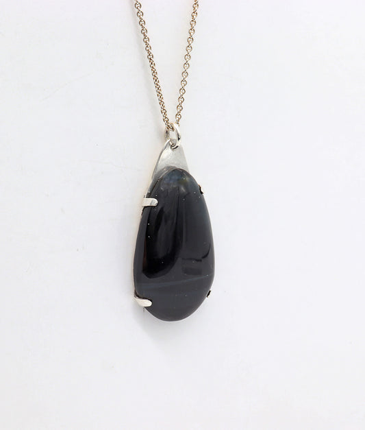 Handcrafted African Blue Tiger's Eye teardrop pendant with deep blue-black reflective gemstone, solid Argentium 935 silver tabbed setting and silver chain.  Show on white background.