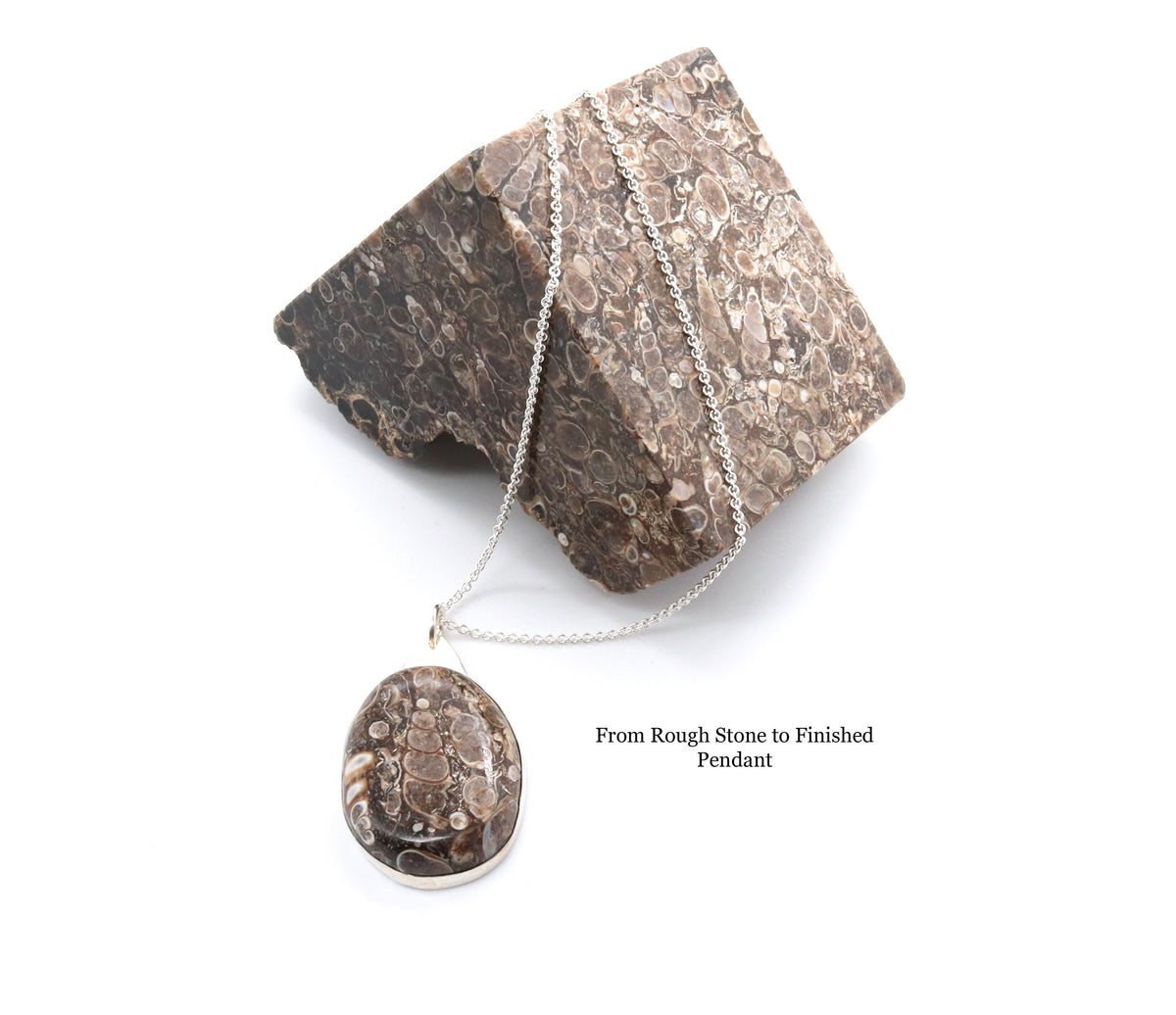 A silver chain necklace with an oval pendant featuring a detailed fossil or stone pattern, displayed against a textured brown stone prop on a white background. Text on the image reads 'From Rough Stone to Finished Pendant'.